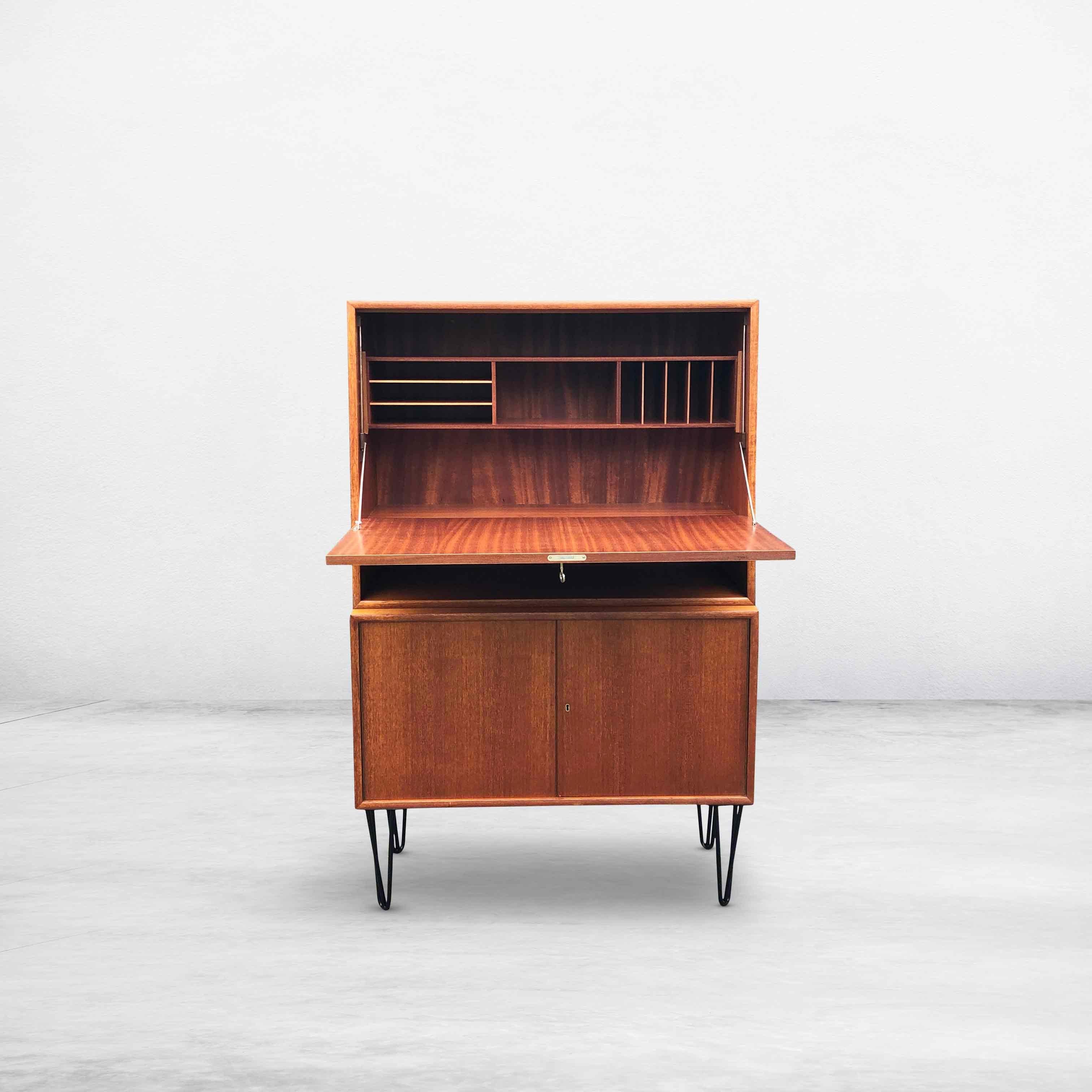 Rare mid-century secretaire/secretary or highboard from the German WK Möbel. This wooden cabinet consists of two separate parts that are placed on top of each other. The upper part is divided into different parts and can be used as a desk or bar.