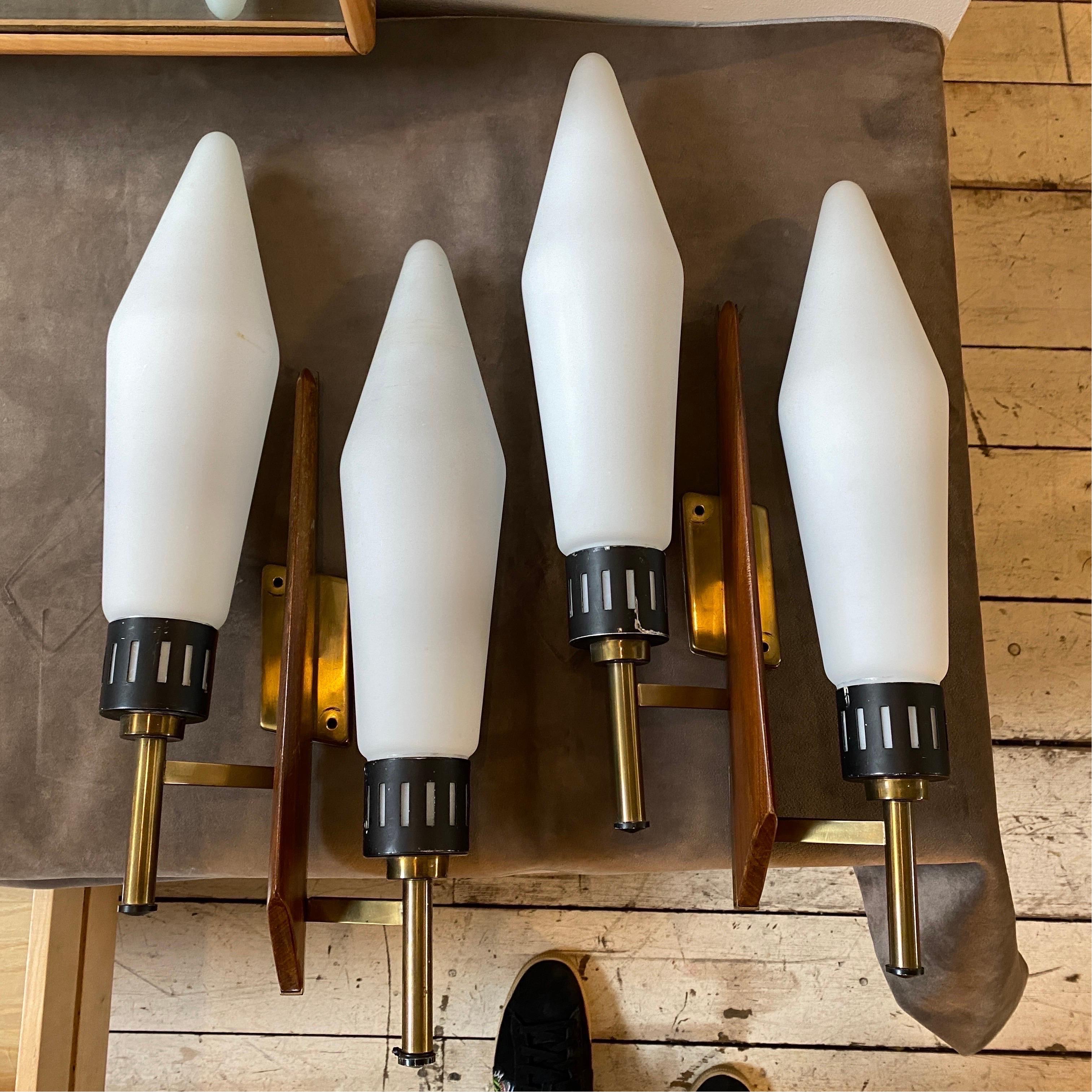 Two amazing brass, teak and white glass wall sconces made in Italy in the Sixties, high quality brass parts, extremely rare glasses and lovely teak shape gives them a superb look. Their large size also gives the function of furnishing the wall as