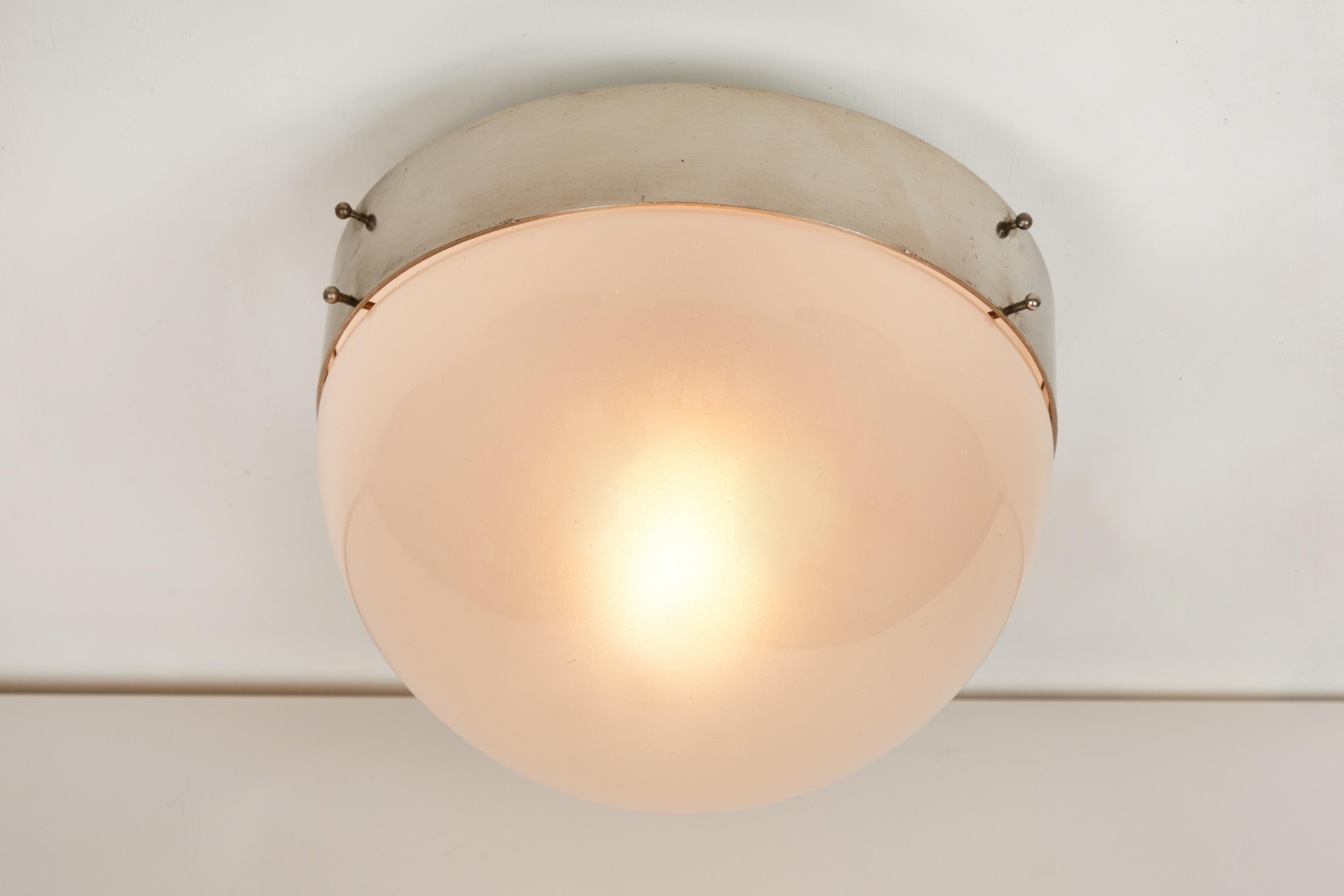 1960s Sergio Mazza 'Demi Clio' wall or ceiling lamp for Artemide. Executed in nickeled brass and opaline glass, Italy, circa 1960s. Clean and architectural, these hardwired lamps emit a pleasingly filtered light through hand blown opaline glass