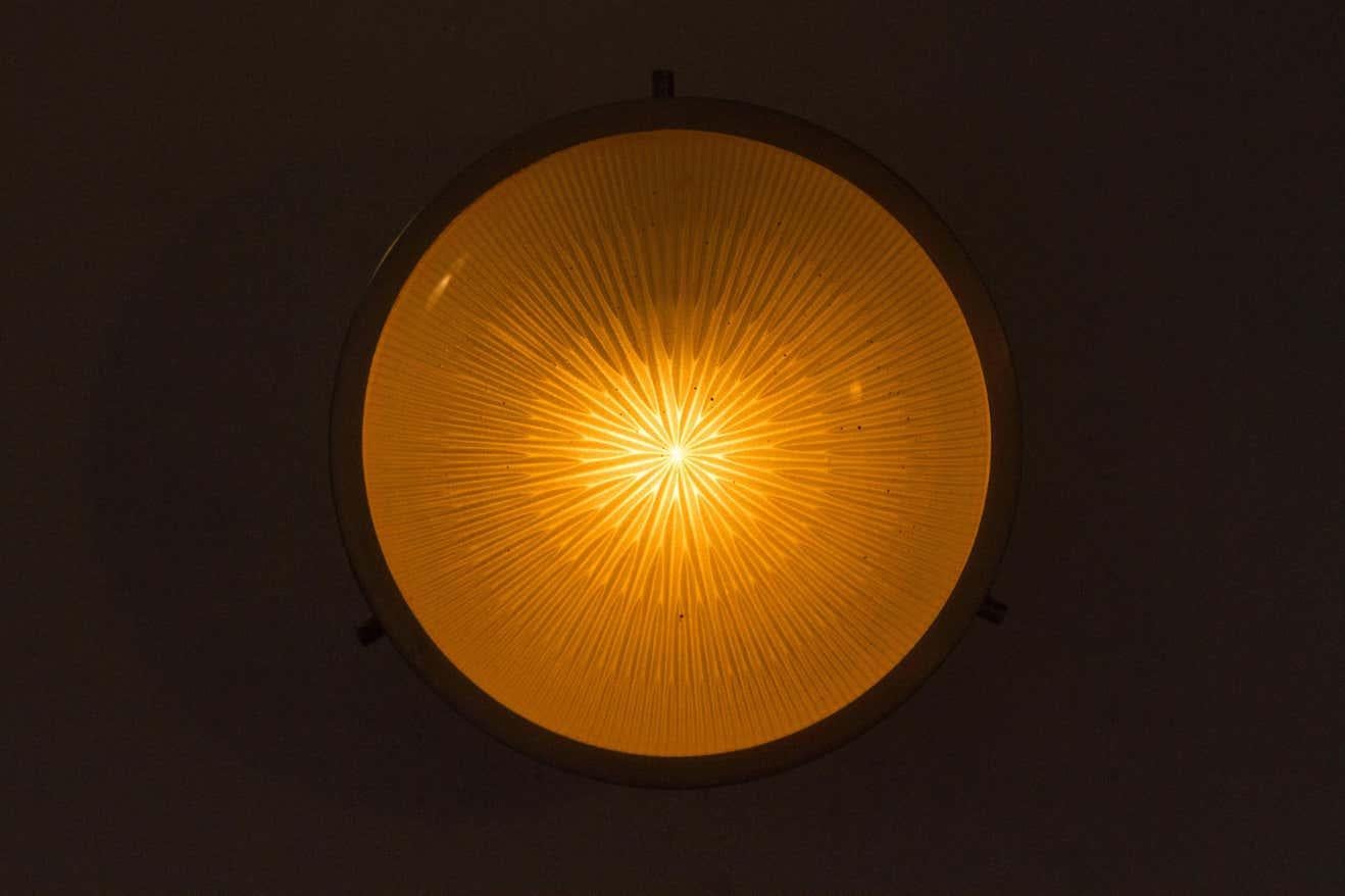 1960s Sergio Mazza Petite 'Sigma' wall or ceiling light for Artemide. Executed in nickeled brass and pressed opaline glass. Minimalist and refined, this iconic lamp can be used for wall or ceiling applications. 

Born in Italy in 1931, Sergio Mazza