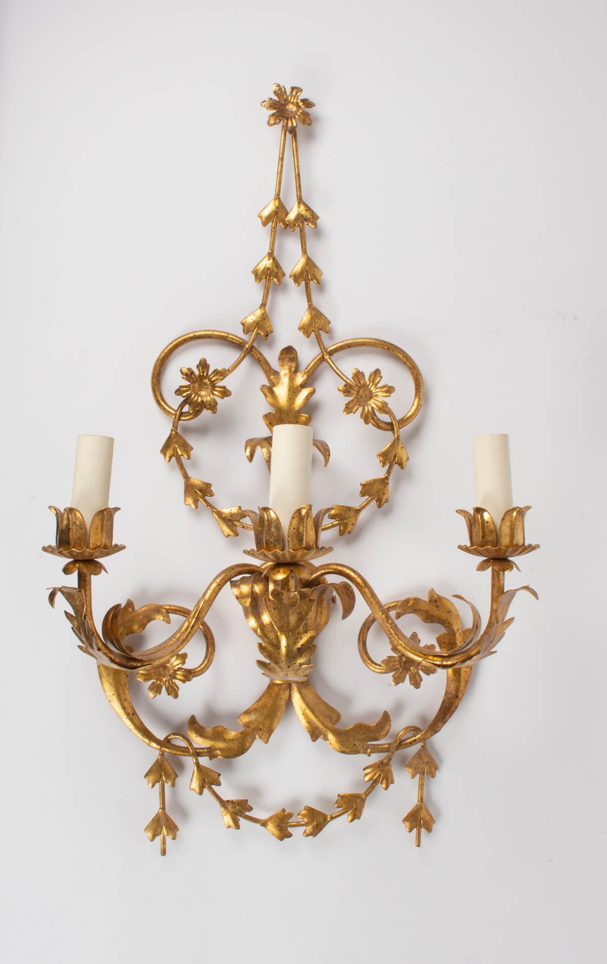 These 3 elegant sconces inspired by the Louis XVI style feature lovely garlands of flowers and foliage, with a beautiful gilded patina. They have been designed by the Maison FlorArt in the 1960s 
3 bulbs per sconces.