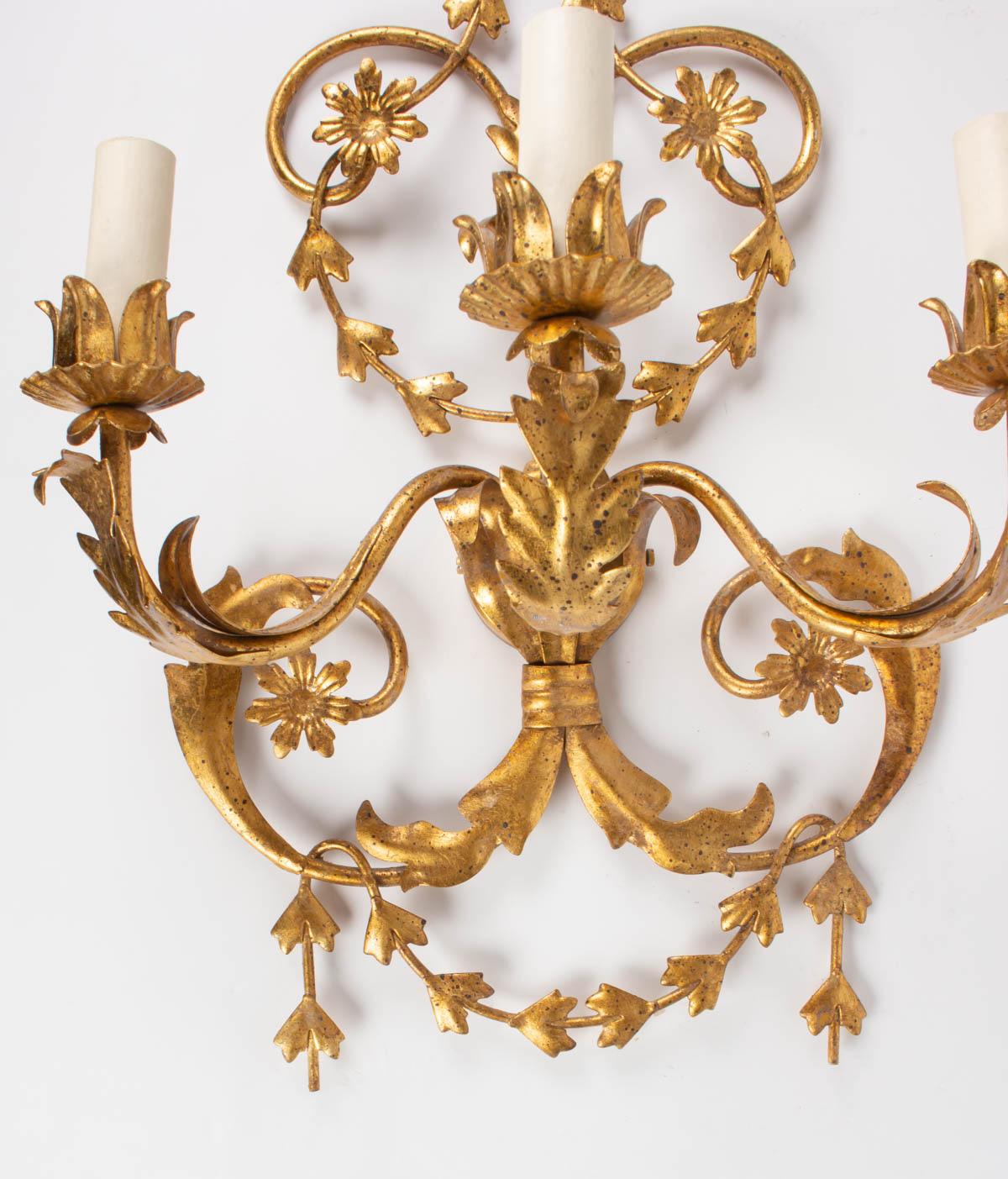 These 3 elegant sconces inspired by the Louis XVI style 
Composed of several garlands of flowers and foliage forming very harmonious and light volutes and counter-volutes.
They are equipped with three arms of light positioned at mid-height of the