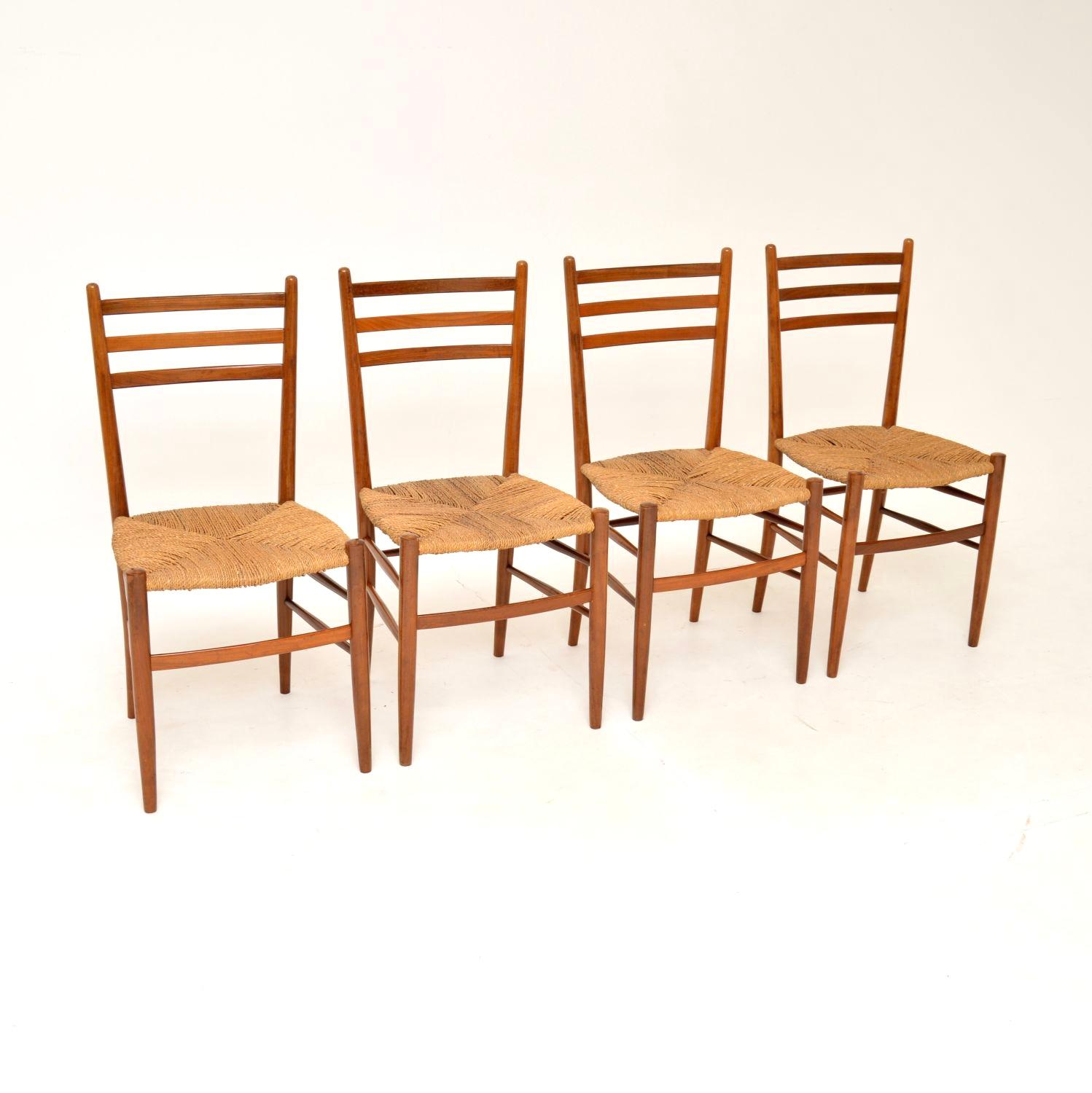 A beautiful and elegant set of four vintage Italian dining chairs in solid walnut. They were made in Italy around the 1960-70’s.

The quality is excellent, they are very well made and stylish. The ladder backs have three horizontal rails, they