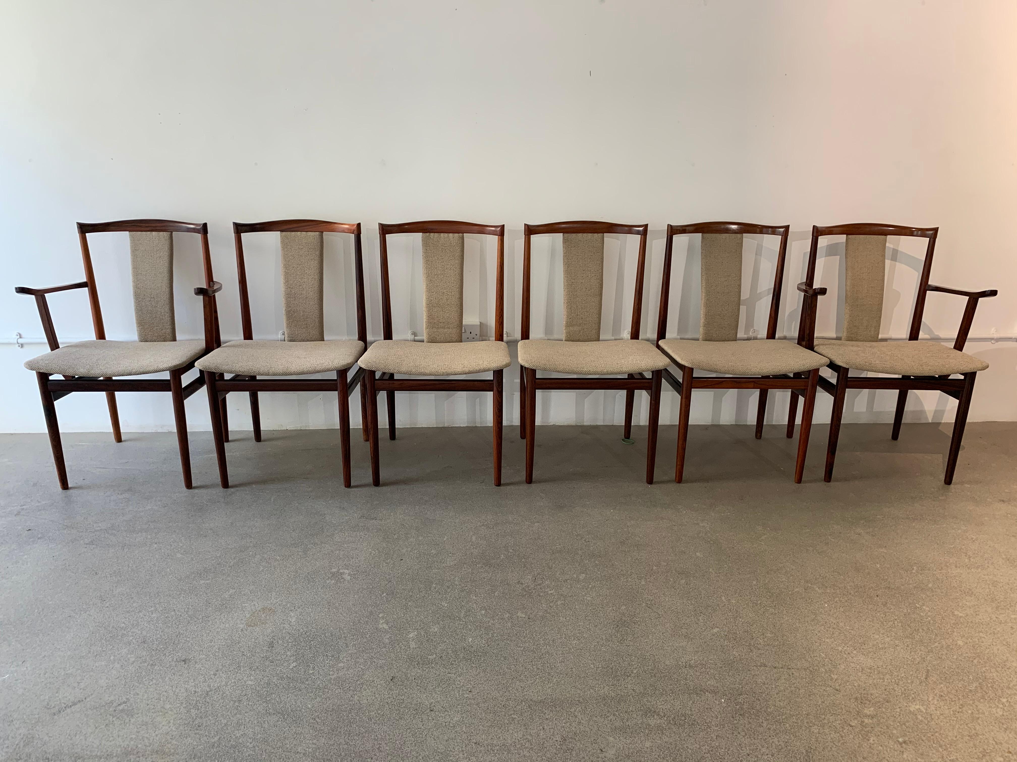 A stunning set of 6 rosewood dining chairs comprised of two carvers and four chairs with their backs and seats recently recovered in a thick, textured, natural oatmeal, bouclé fabric. Designed by Henning Sorensen for Dan-ex in 1968.

Each chair