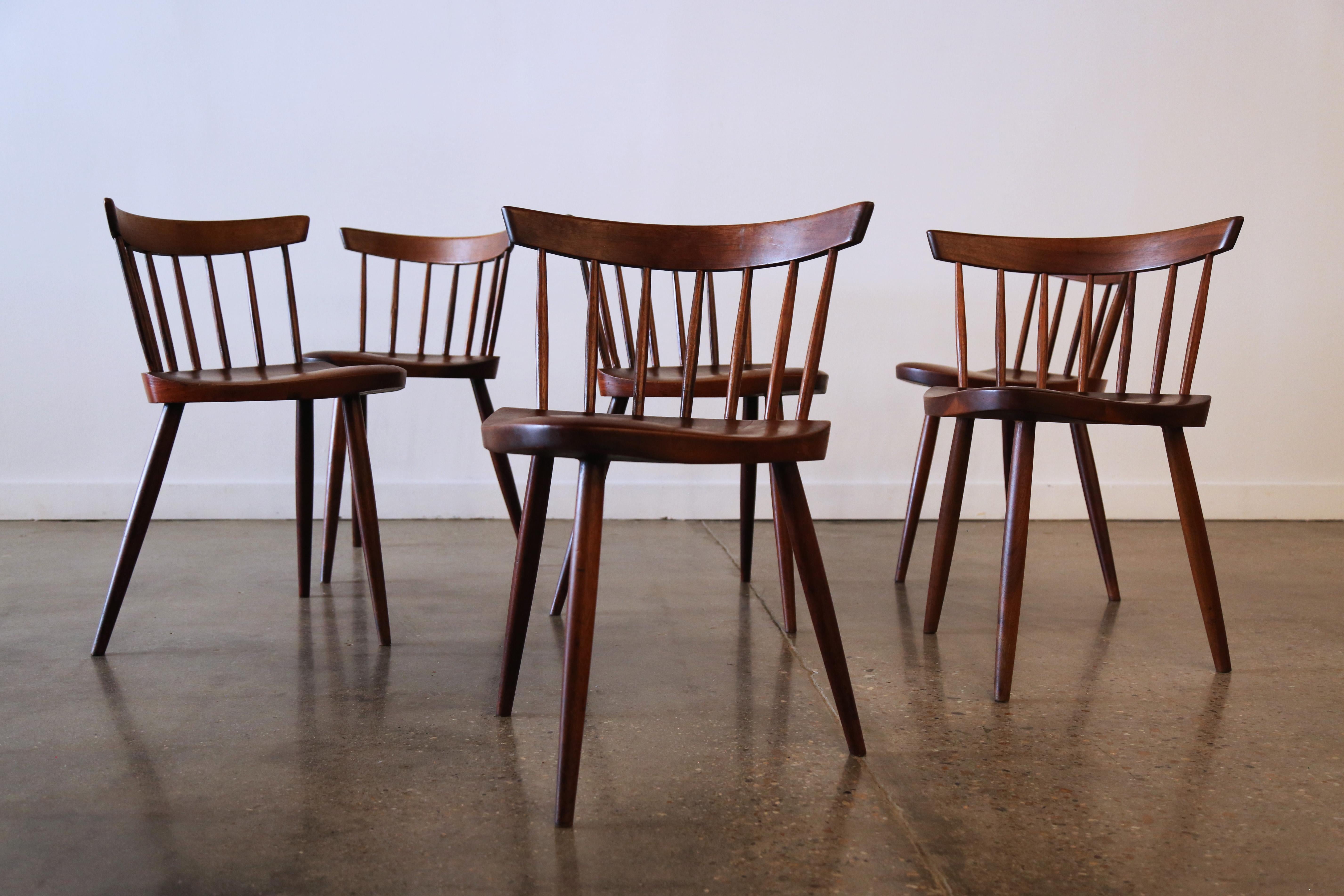Ein Satz von 6 Mira-Stühlen, entworfen von George Nakashima und hergestellt von Gino Russo. Dieses Set aus 6 Mira-Stühlen aus massivem Kirschbaumholz steht auf drei Beinen mit einer geformten Sitzfläche und handgedrechselten Spindeln. Dieselben