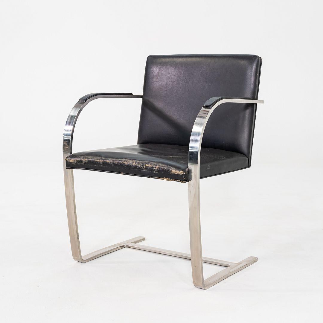 Se trata de un conjunto de ocho sillas Flat Bar Brno, diseñadas originalmente por Mies van der Rohe en 1929 y producidas por Knoll en la década de 1960. Estas sillas icónicas presentan armazones de acero inoxidable de barras planas con formas en