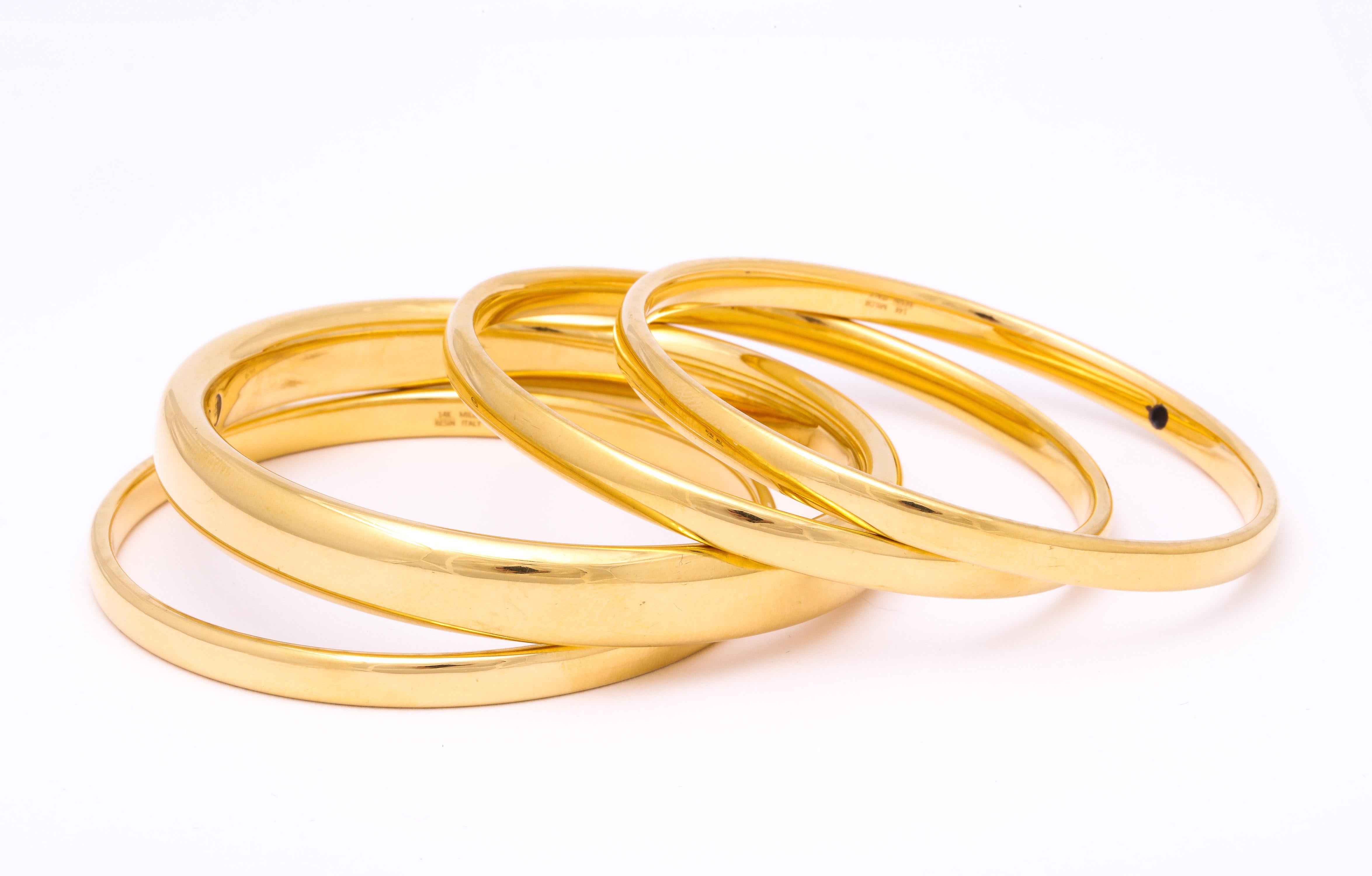 Set Of Four 14kt High Polish Gold Bangles One Large One Approximately .40 of and inch And Other Three Bangles Approximately .25 Of an Inch Wide. Crafted In The 1960's In Italy.Fits Standard Wrist Size.