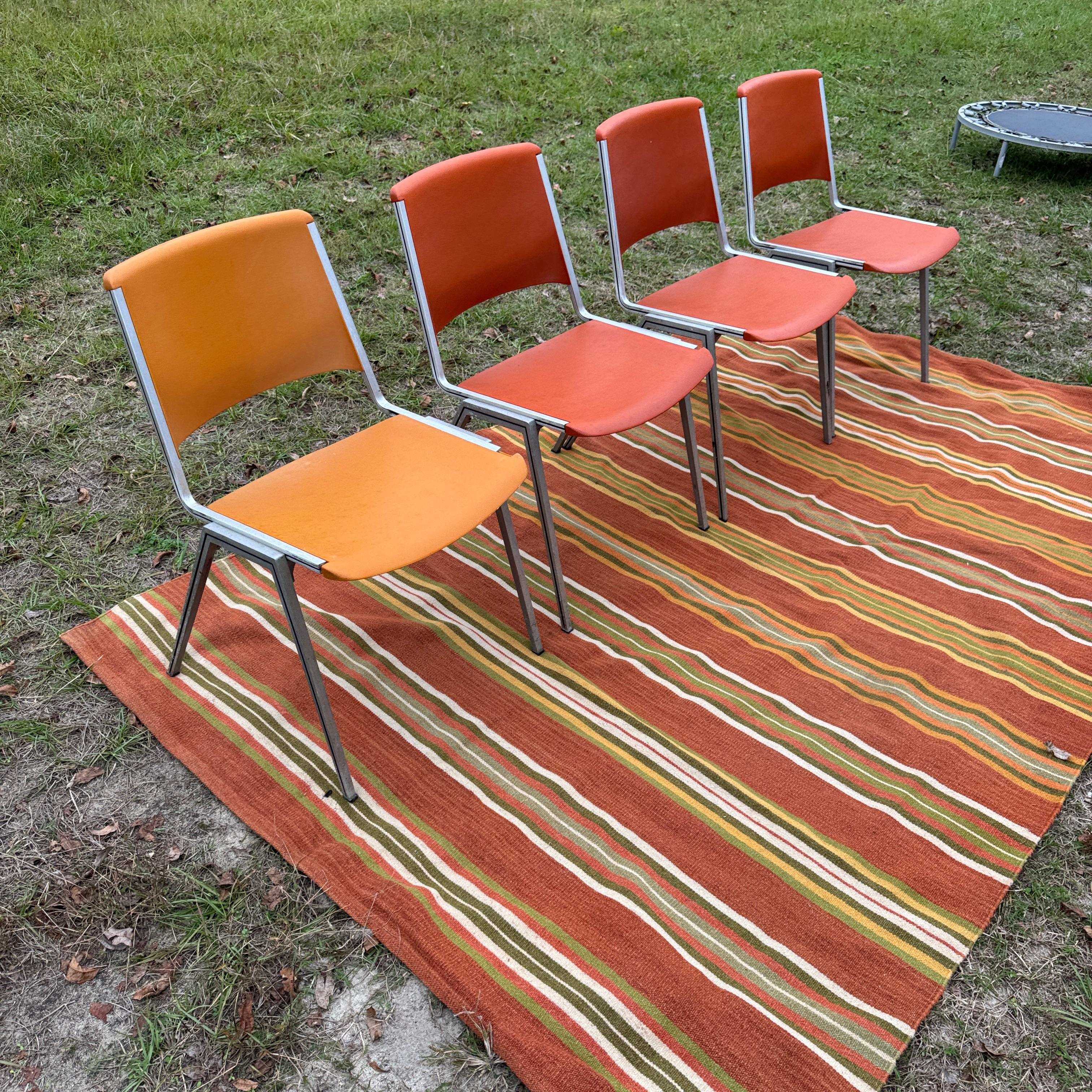 Nous avons le plaisir de vous présenter ce fantastique ensemble de quatre chaises d'appoint empilables Steelcase, de couleur orange et ocre. La couleur est indéniablement rétro dans tous les sens du terme. L'assise et le dossier sont en plastique