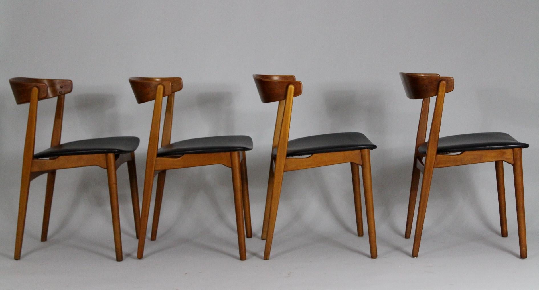 Set of four Scandinavian dining chairs from the 1960s. Material is beech and teak, seat is in black faux leather. Very good condition.