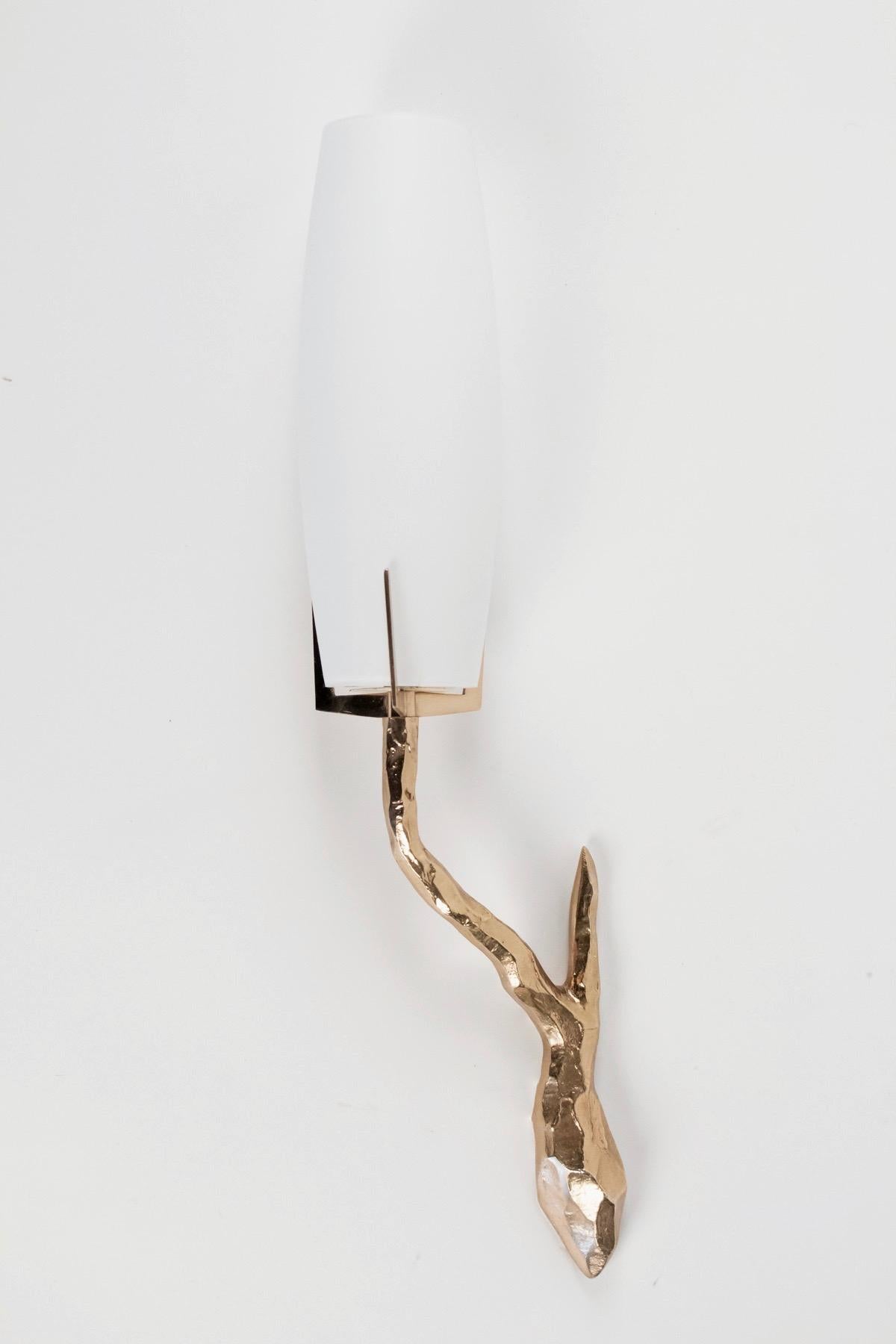 High quality sconces, all made of gilded bronze manufactured by Maison Arlus in the 1960s.
The arms are ended with the original cylindrical shades of white opaline glass.
The arms figure wooden branch or lightning bolt, their design can be