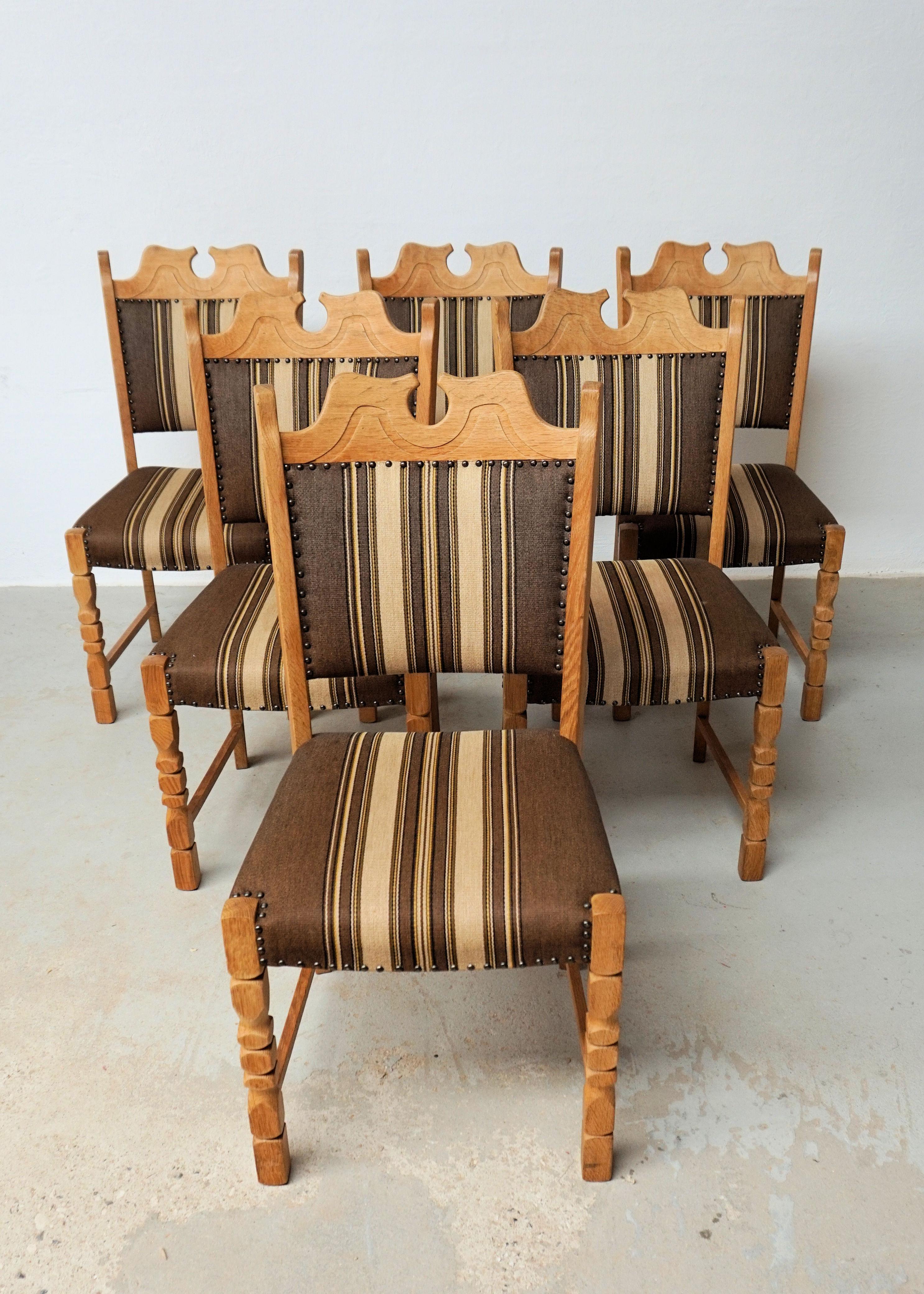 1960's Set of Six Danish Oak Dining Chairs in Henning Kjaernulf Brutalist Style

The set of 6 chairs in Henning Kjærnulf's characteristic brutalist style where he combined a modern look with playful hints to historical chairs, feature sturdy frames