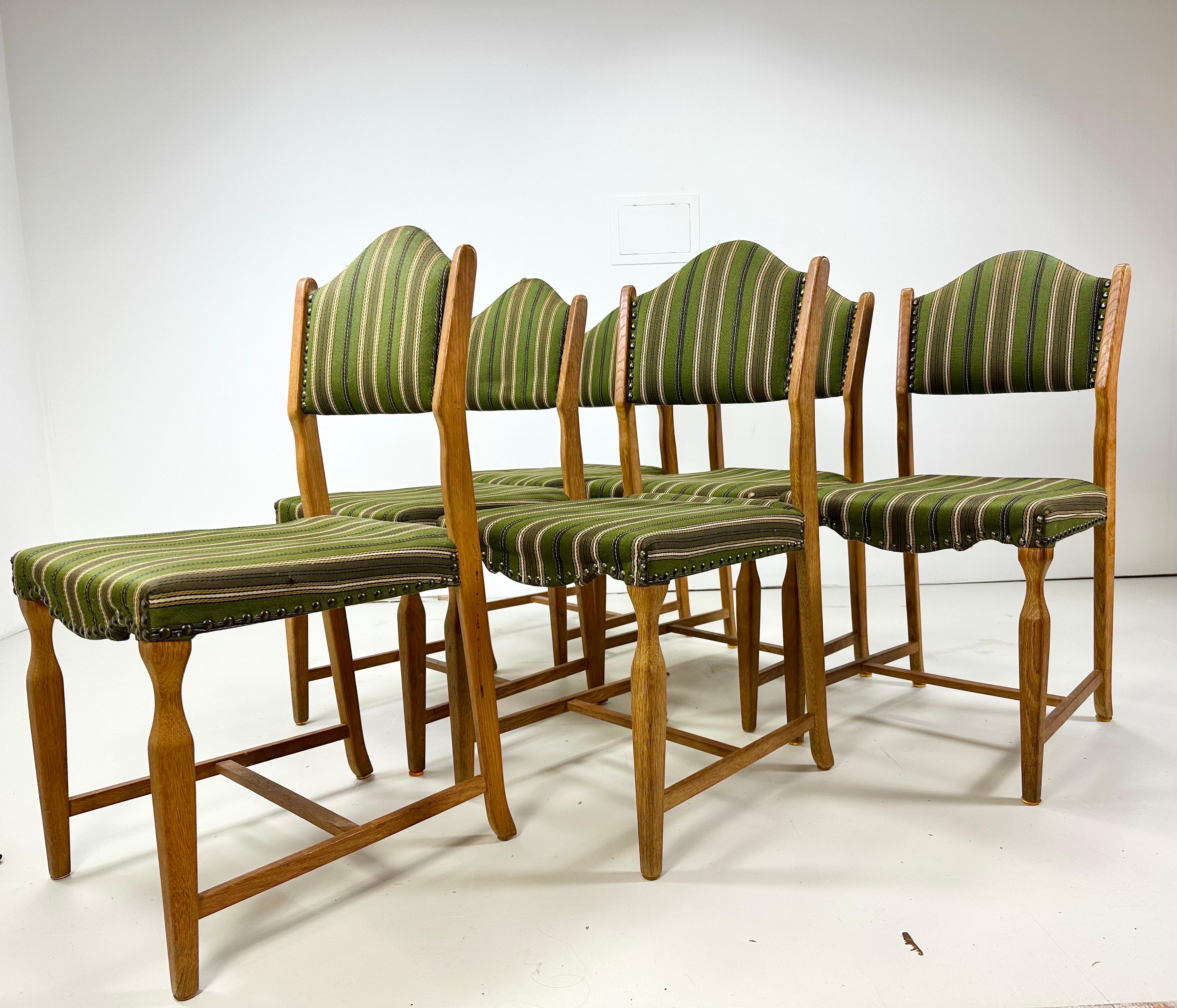 Set of 6 Dining Chairs designed by Henning Kjaernulf. Manufactured by EG Kvalitesmobel, Denmark, 1960’s. Chairs have a rustic warm finish and lines along with some classic mid century elements. Original upholstery and nailheads.

Delivery To NYC