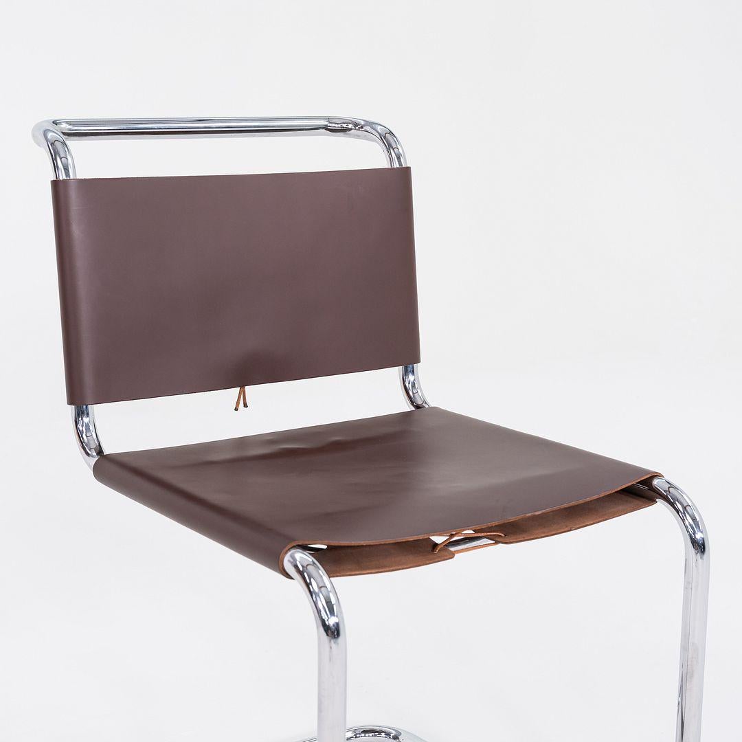 This is a set of six B33 Cantilever Side Chairs, originally designed by Marcel Breuer in 1928. These particular examples were produced by Knoll in the 1960s. They feature a tubular steel frame and are upholstered in brown leather, which appears to