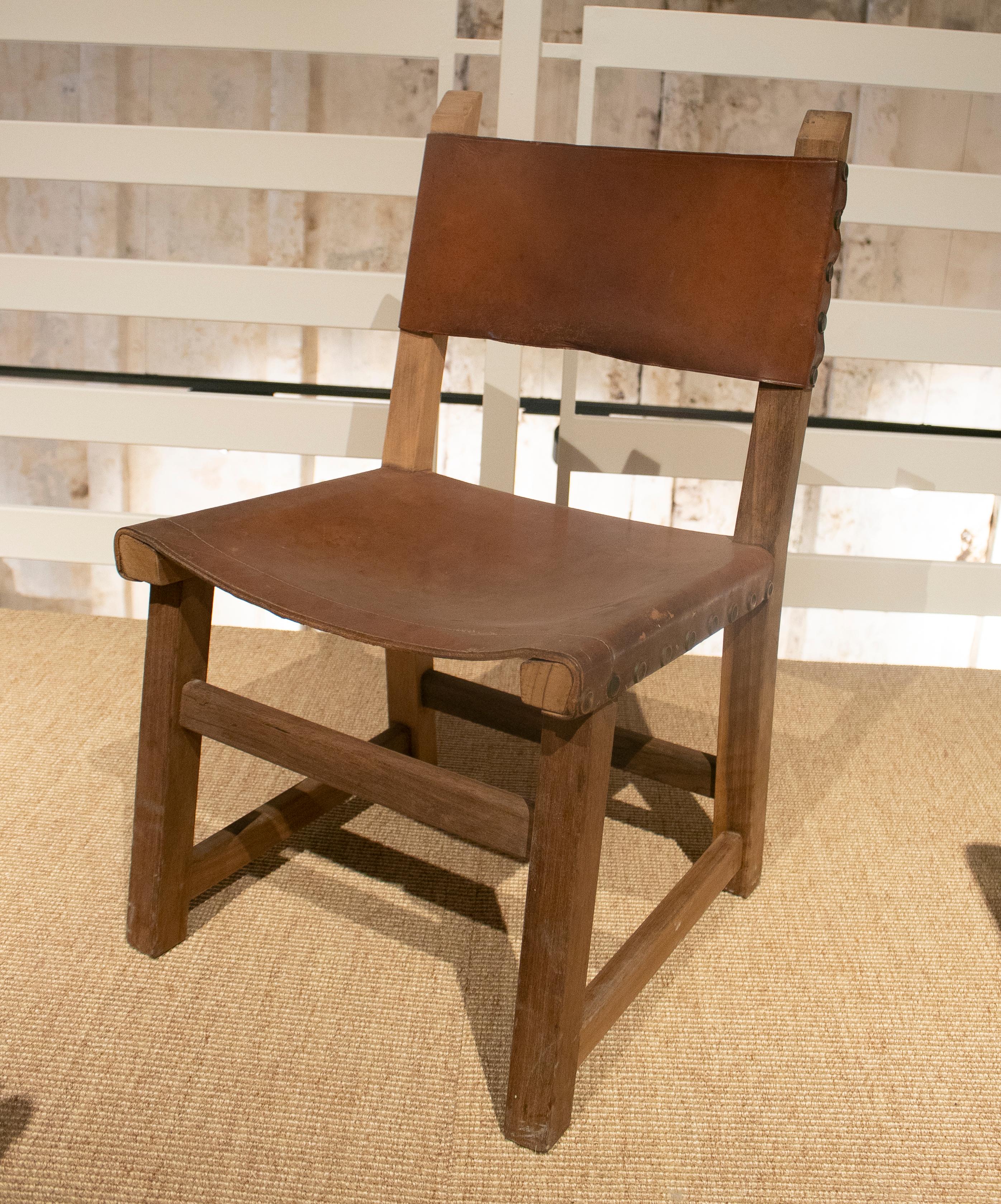 Ensemble de six chaises espagnoles en bois et en cuir datant des années 1960.