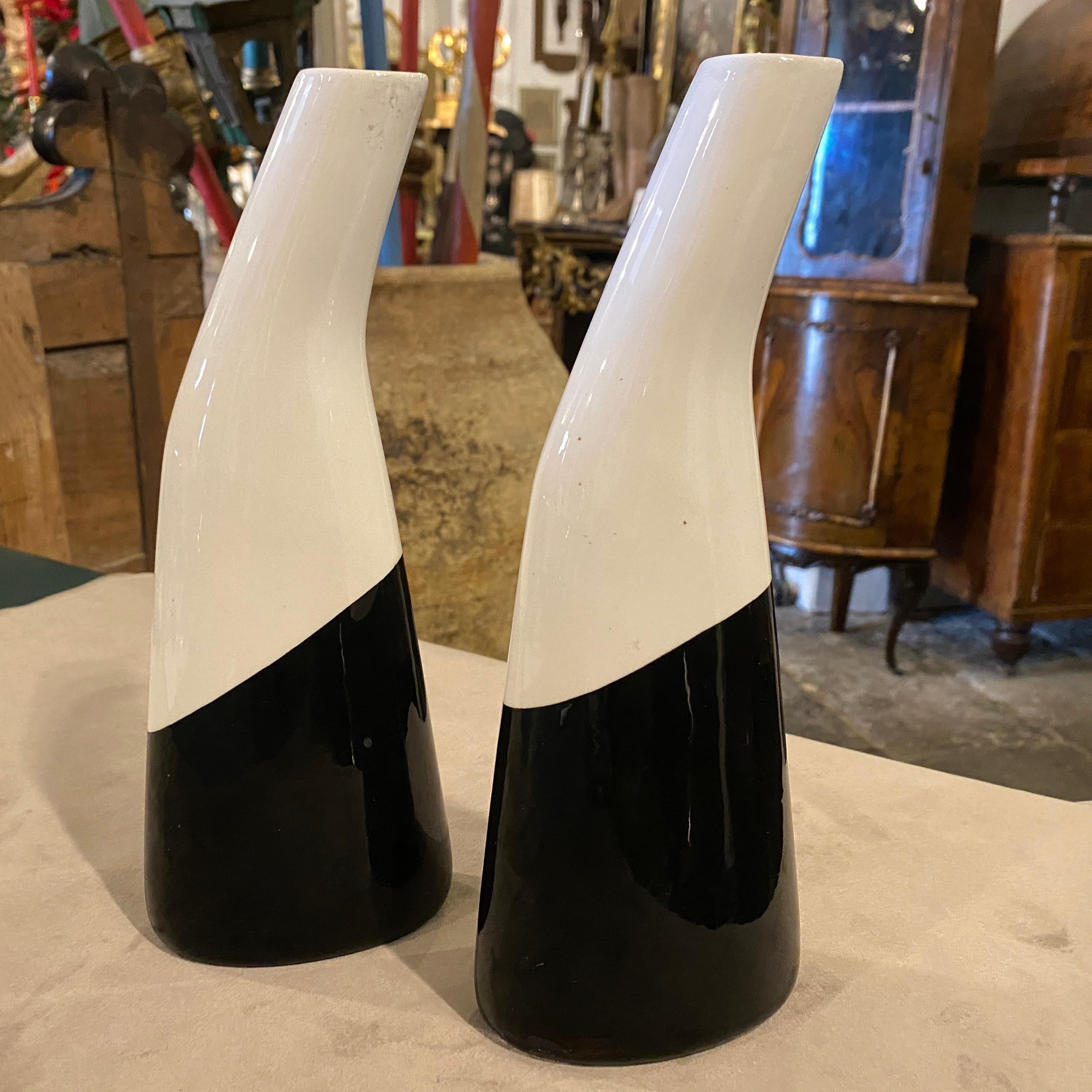 Coppia di vasi in ceramica bianca e nera prodotti in Italia da La Donatella negli anni Sessanta, in ottime condizioni e firmati sul fondo. Questo set è un esempio lampante dell'eleganza del design di metà secolo. Ogni vaso incarna l'estetica