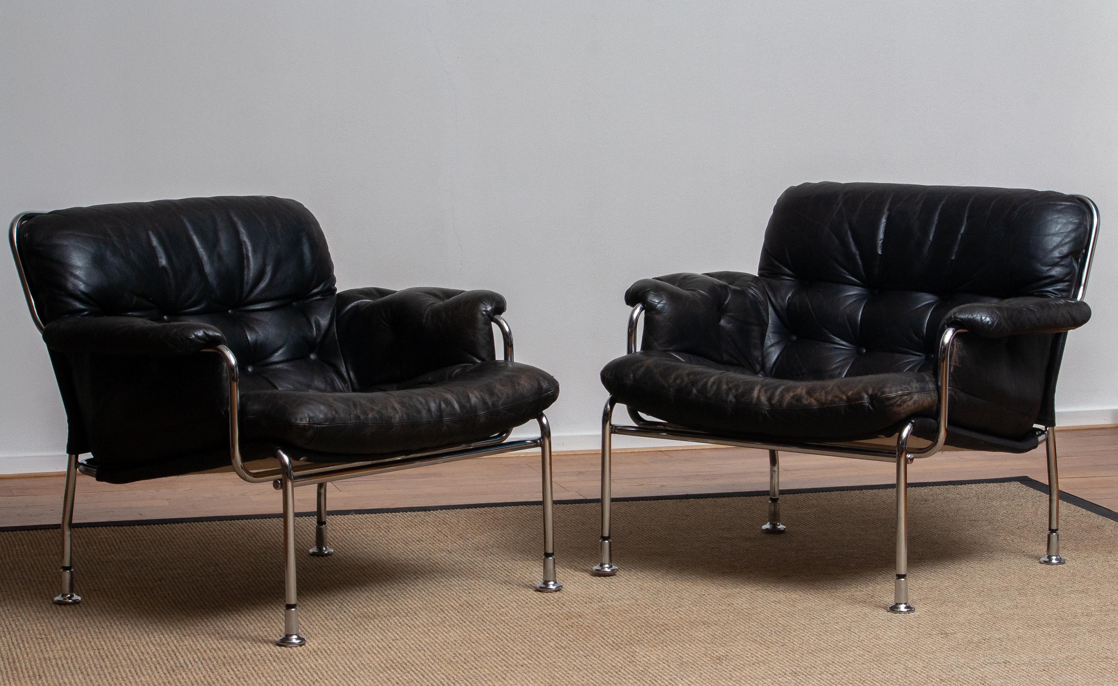 Beautiful set of two lounge / easy chairs in aged black leather and chrome designed by Pethrus Lindlöfs for A.B. Lindlöfs Möbler Lammhult Sweden. Model Eva.
The aged leather on both chairs gives these chairs the typical vintage character. The