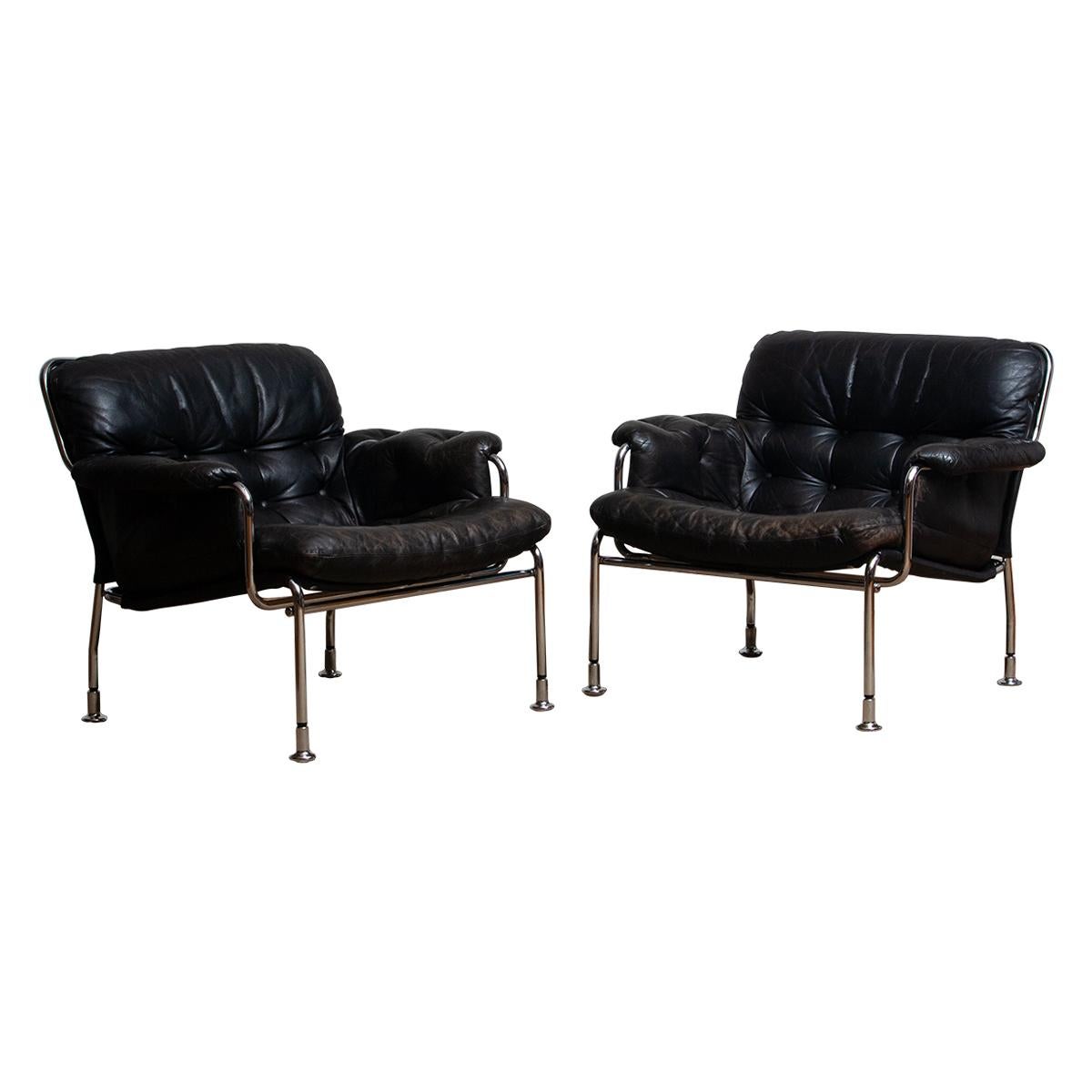 Beautiful set of two lounge / easy chairs in aged black leather and chrome designed by Pethrus Lindlöfs for A.B. Lindlöfs Möbler Lammhult Sweden. Model Eva.
The aged leather on both chairs gives these chairs the typical vintage character. The