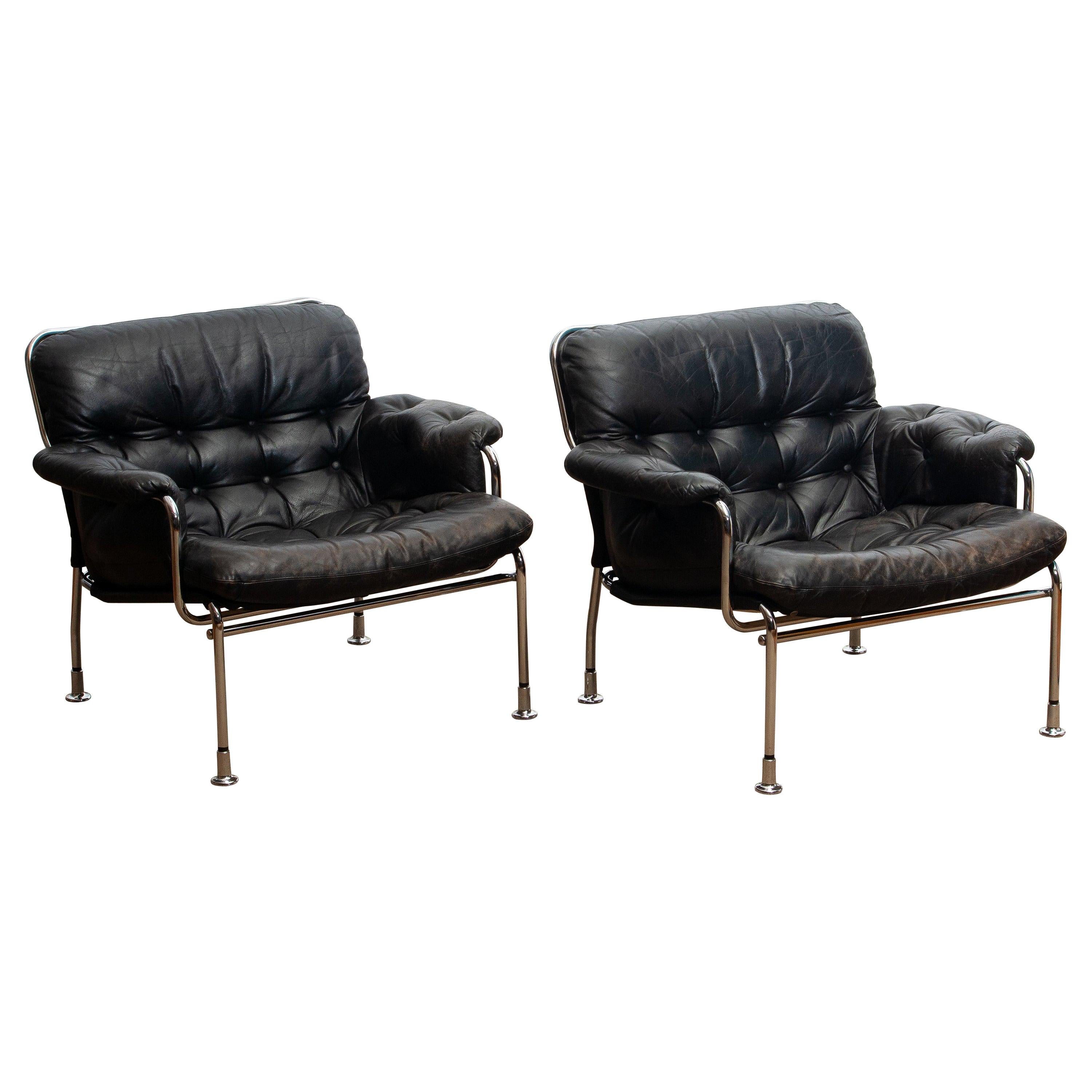 Beautiful set of two lounge / easy chairs in aged black leather and chrome designed by Pethrus Lindlöfs for A.B. Lindlöfs Möbler Lammhult, Sweden. Model Eva.
The aged leather on both chairs gives these chairs the typical vintage character. The