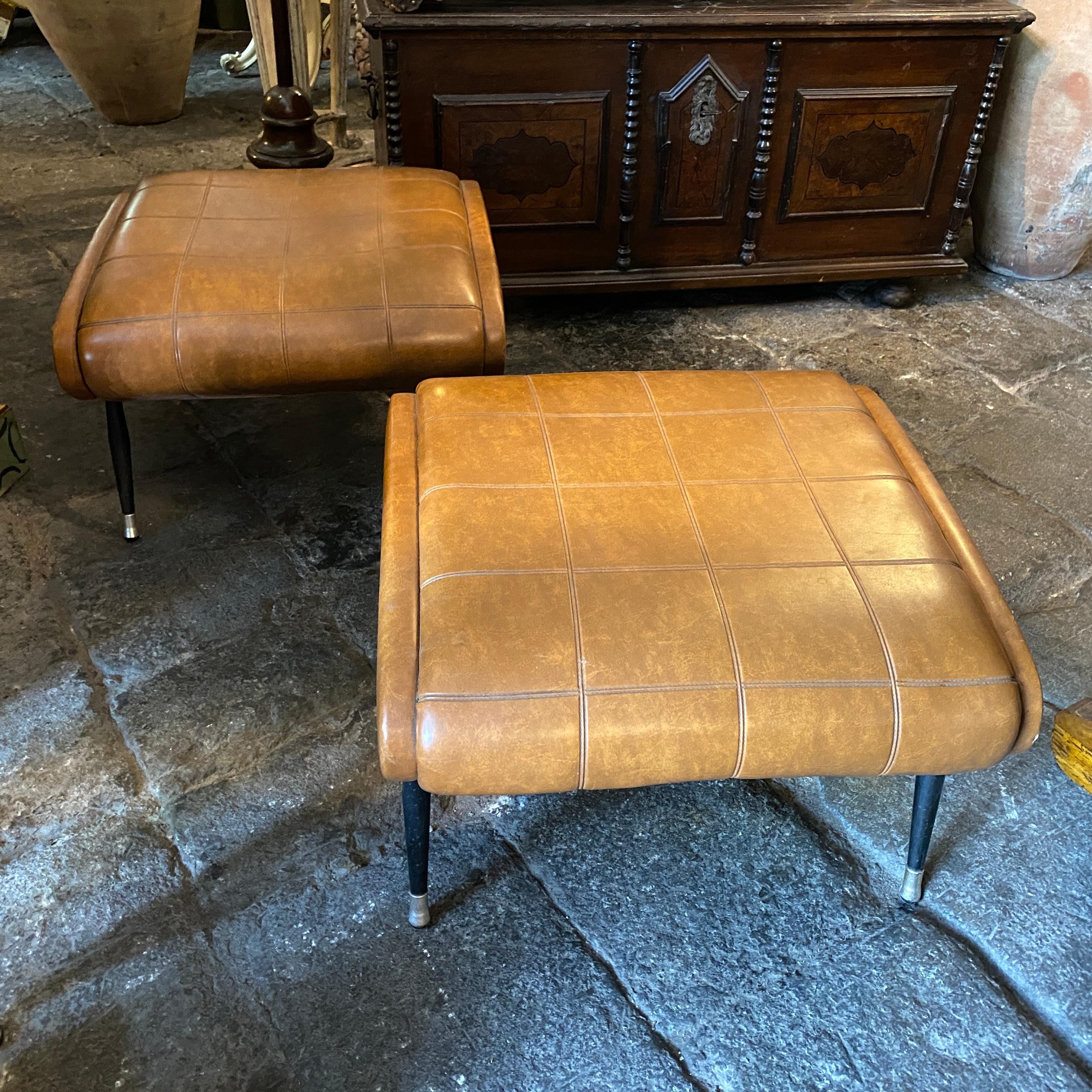 A lovely pairs of mid-century modern brown faux leather and iron poufs designed and manufactured in Italy in the Sixties. They are in good condition.