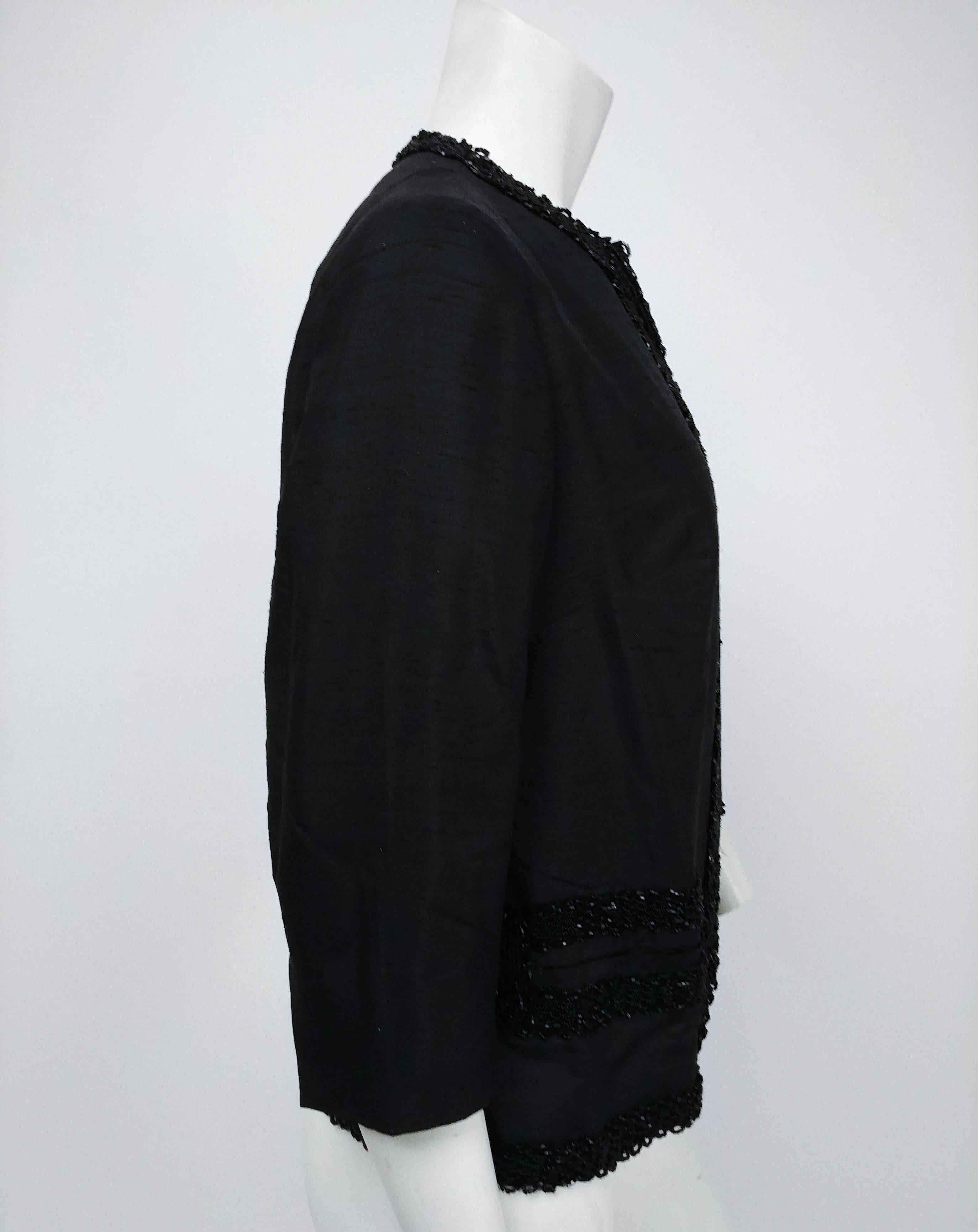 1960s Shantung Black Beaded Evening Jacket. Collarless 1960s jacket with beaded trim, glove length sleeves, and classic boxy silhouette. Two front welt pockets. 