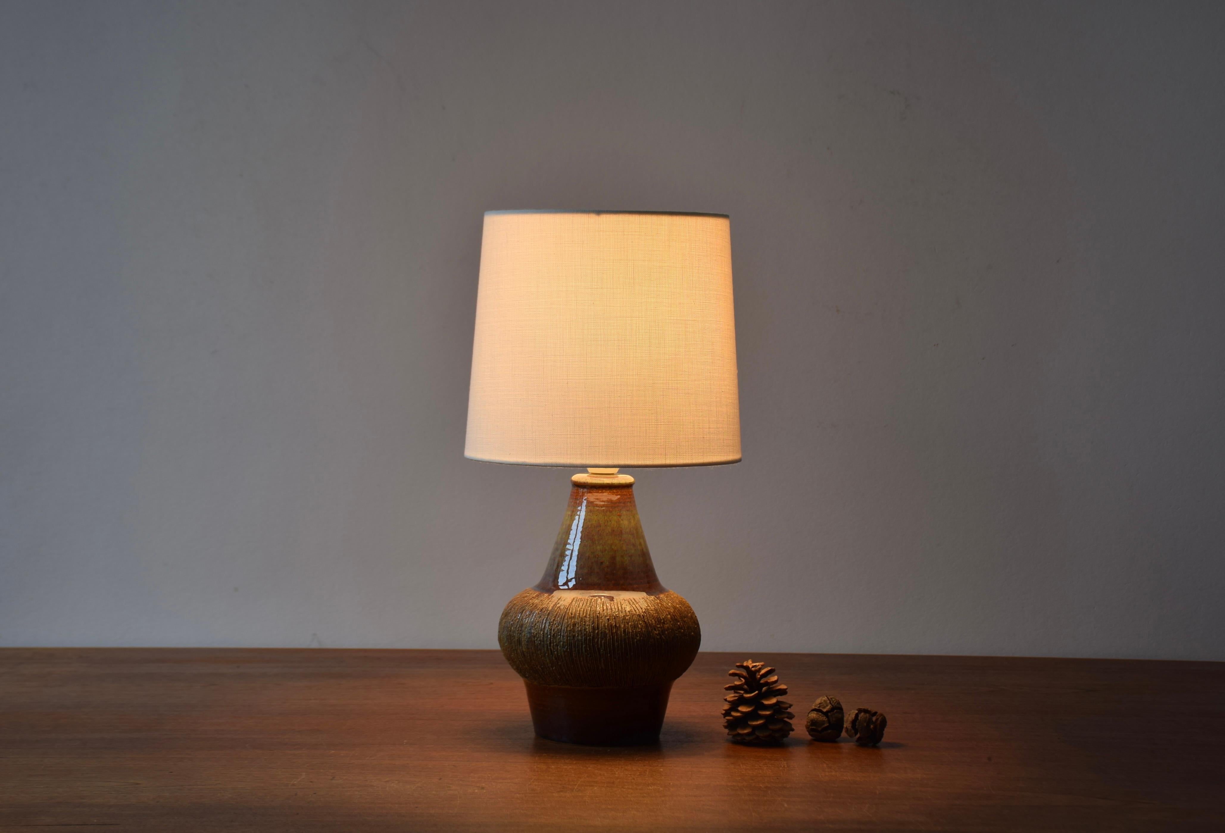 Sculptural table lamp from Søholm Stentøj, Denmark.
Designed by Gerd Hiort Petersen and made circa 1960s.
Great play of glaze colors on neck and with engraved stripe decor.

Included is a new clip-on-bulb lamp shade designed and made in Denmark. It