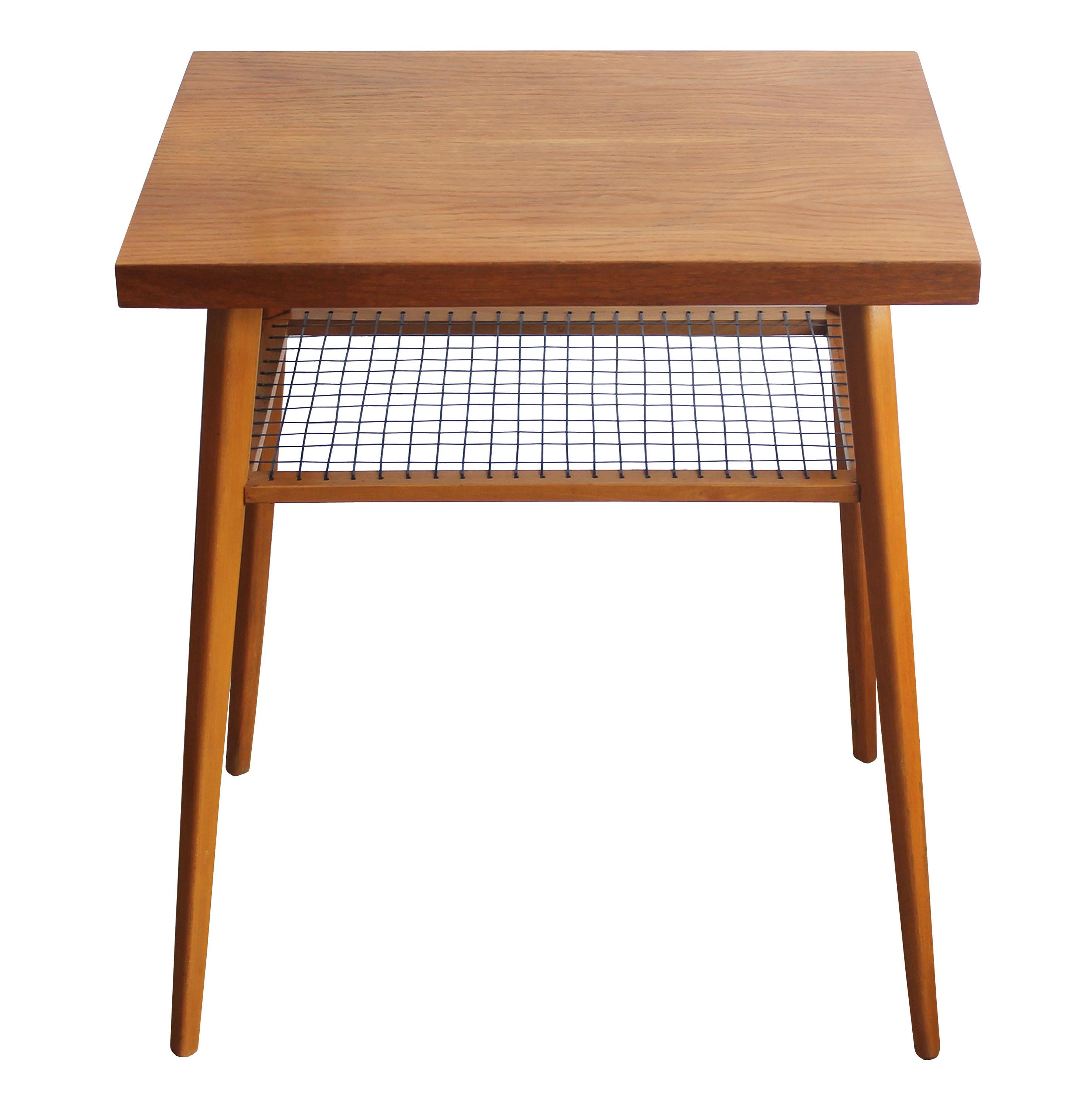 This side table was produced in 1960’s in former Czechoslovakia. It was originally sold as a radio or tv table, with the low shelf (made of navy string) being used for newspaper or magazines. At the time this was a very popular piece of furniture