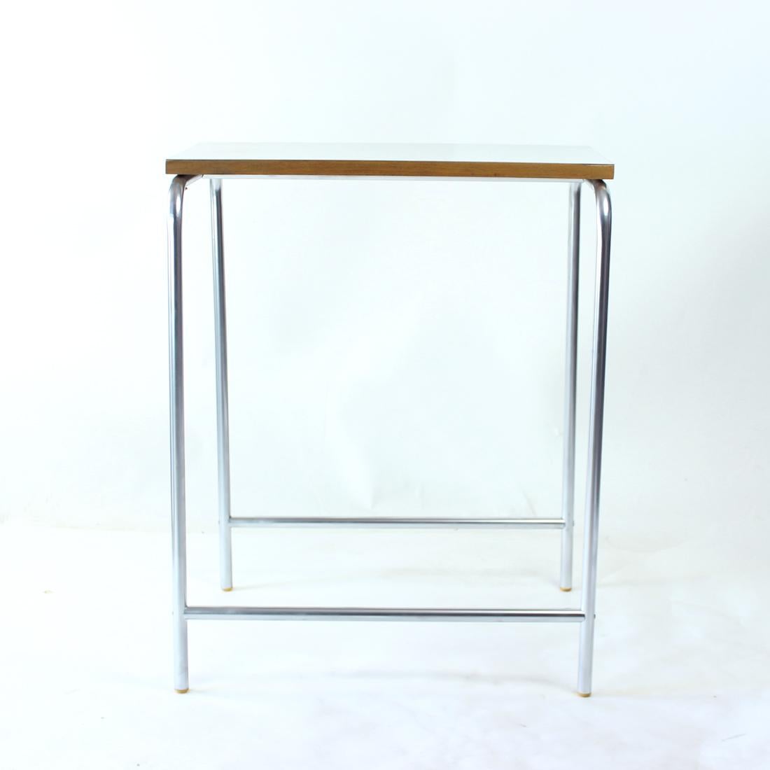 Superbe table d'appoint vintage produite en Tchécoslovaquie dans les années 1960. L'étiquette d'origine est encore attachée au bas de la planche supérieure. La table est construite à partir de tubes d'acier pliés, avec une finition au pistolet de
