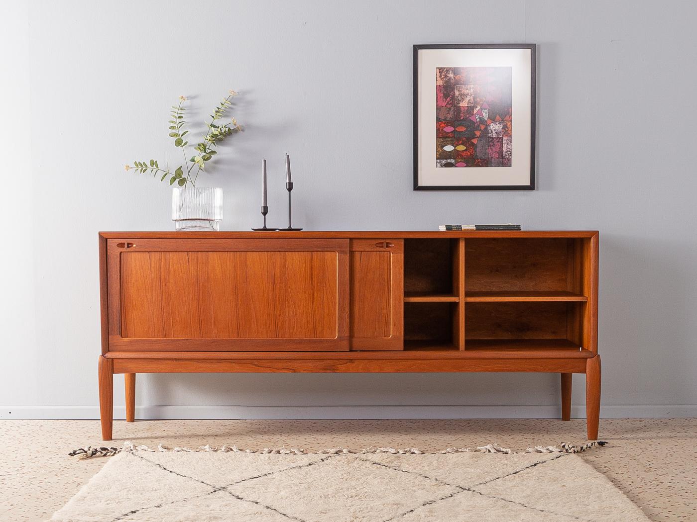 Classic sideboard from the 1960s by H.W. Klein for Bramin. High quality corpus in teak veneer with two sliding doors, two shelves and solid wood feet.

Quality features:
 Accomplished design: perfect proportions and visible attention to detail.
