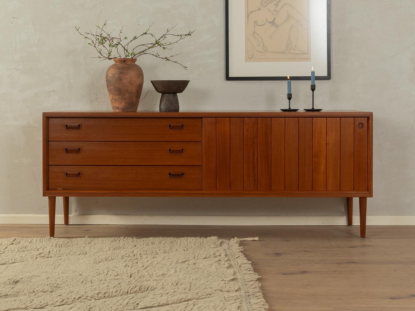Rare sideboard from the 1960s by Munch Møbler. High quality corpus in teak veneer with three drawers, one sliding door, one shelf and cigar shaped feet.
Quality Features:

    accomplished design: perfect proportions and visible attention to detail
