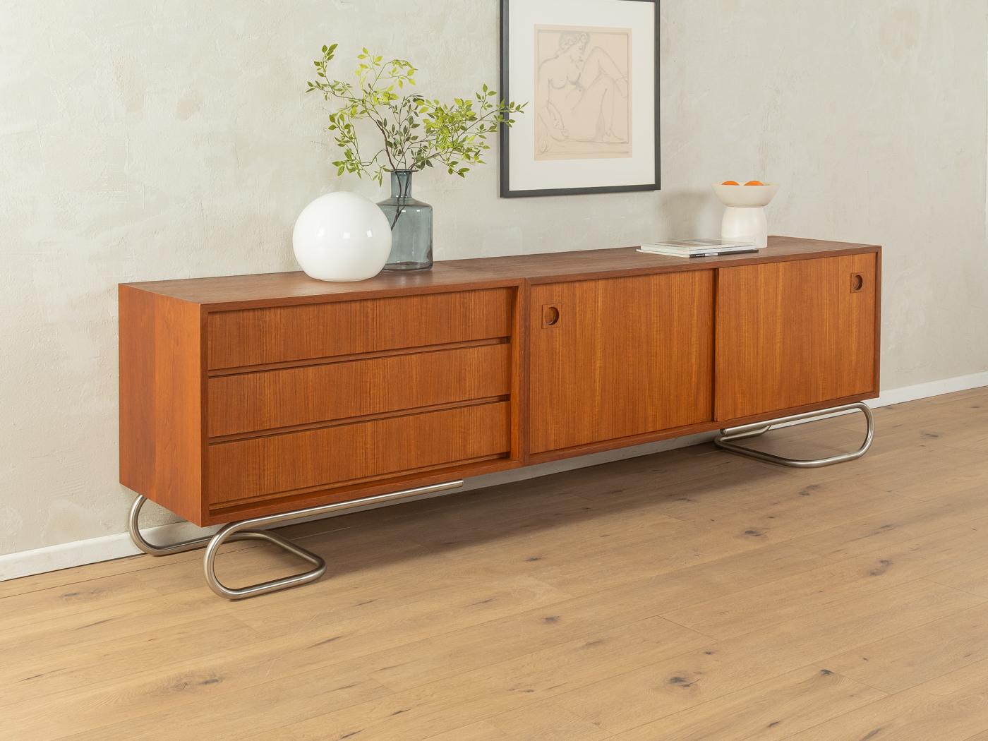 Unique sideboard from the 1960s. High-quality corpus in walnut veneer with three drawers, two sliding doors and new stainless steel feet in Bauhaus design. 

Quality Features:
very good workmanship
high quality materials
mortise & tenon solid wood