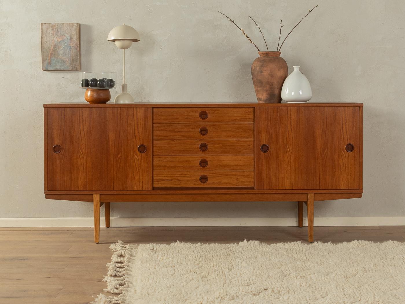 Rare freestanding sideboard from the 1960s by Svensk Möbelindustri. High-quality corpus in teak veneer with five drawers, two sliding doors, two shelves and filigree feet.
Quality Features:

    accomplished design: perfect proportions and visible