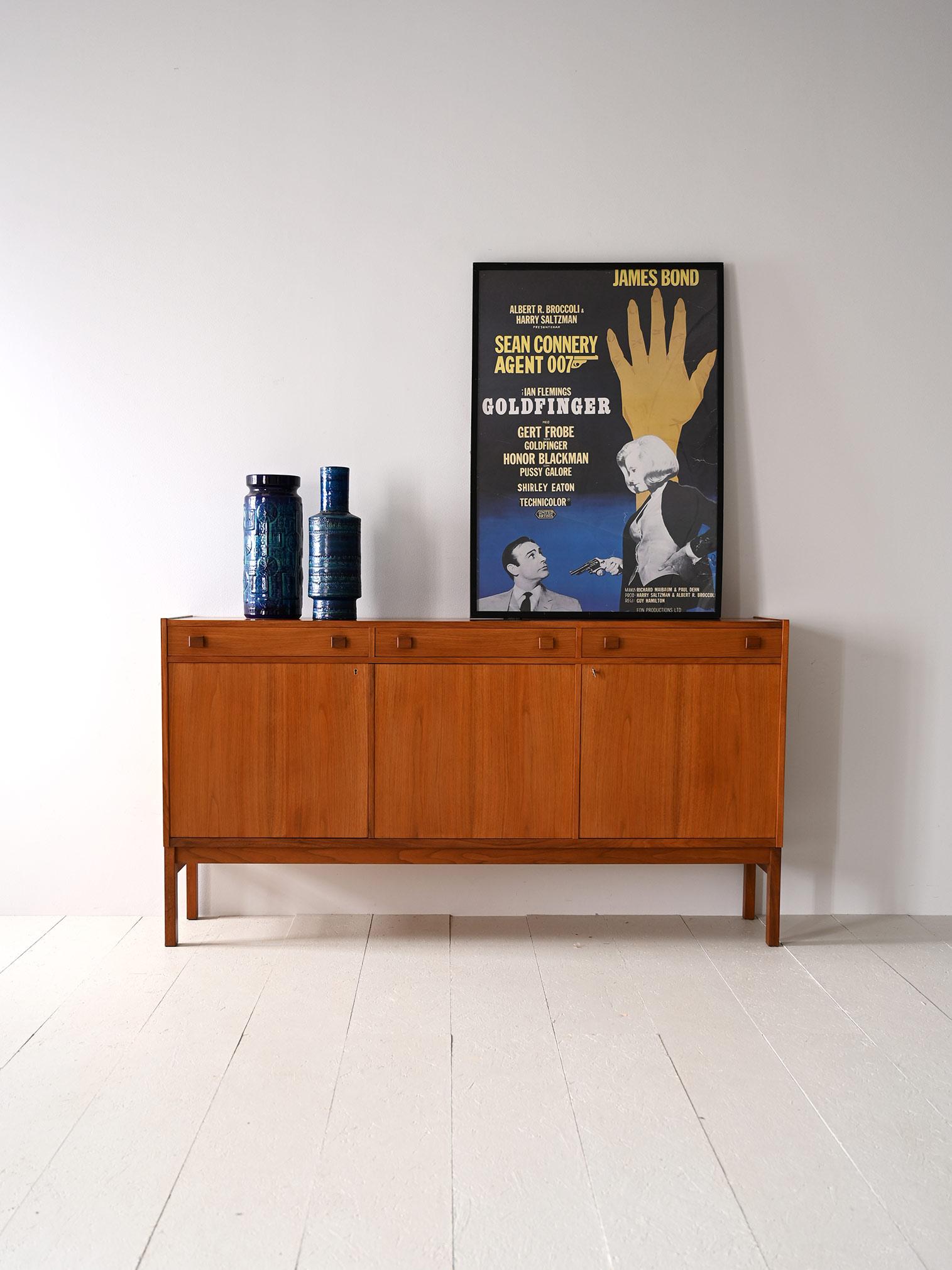 Vintage Scandinavian sideboard with hinged doors.

A piece of furniture with modern lines that trace the taste of the 1950s/60s.
The structure externally is symmetrical and divided into three compartments above which are the three drawers.