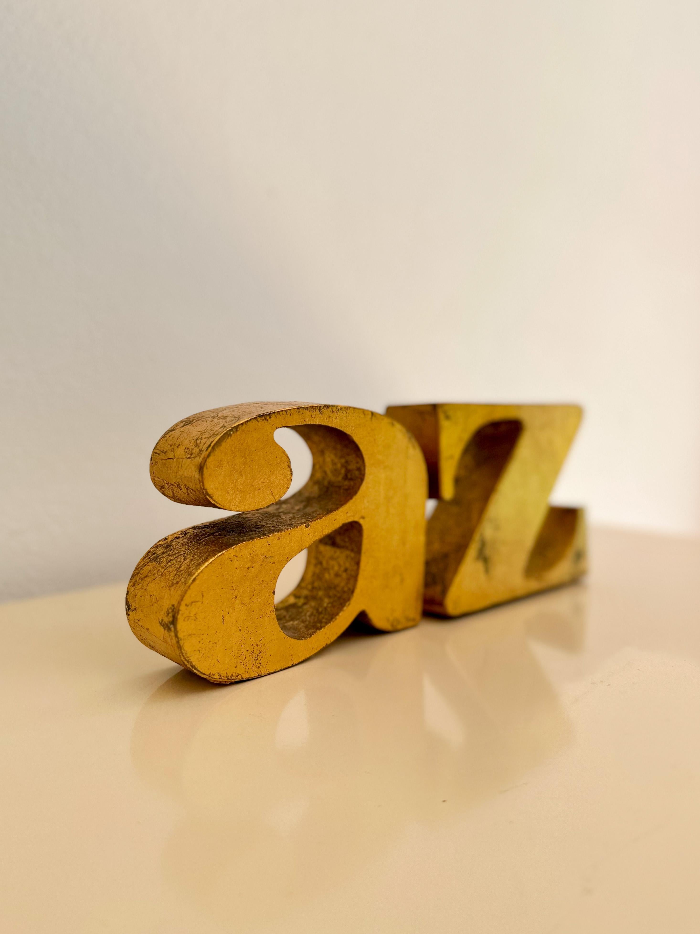 Stately and heavy A-Z cast iron bookend with gilded gold finish by artist Curtis Jeré, c.1960s. These incredible bookends are made of cast iron coated with gold leaf, and weigh in at an astounding 15lbs. Classic serif design is timeless and