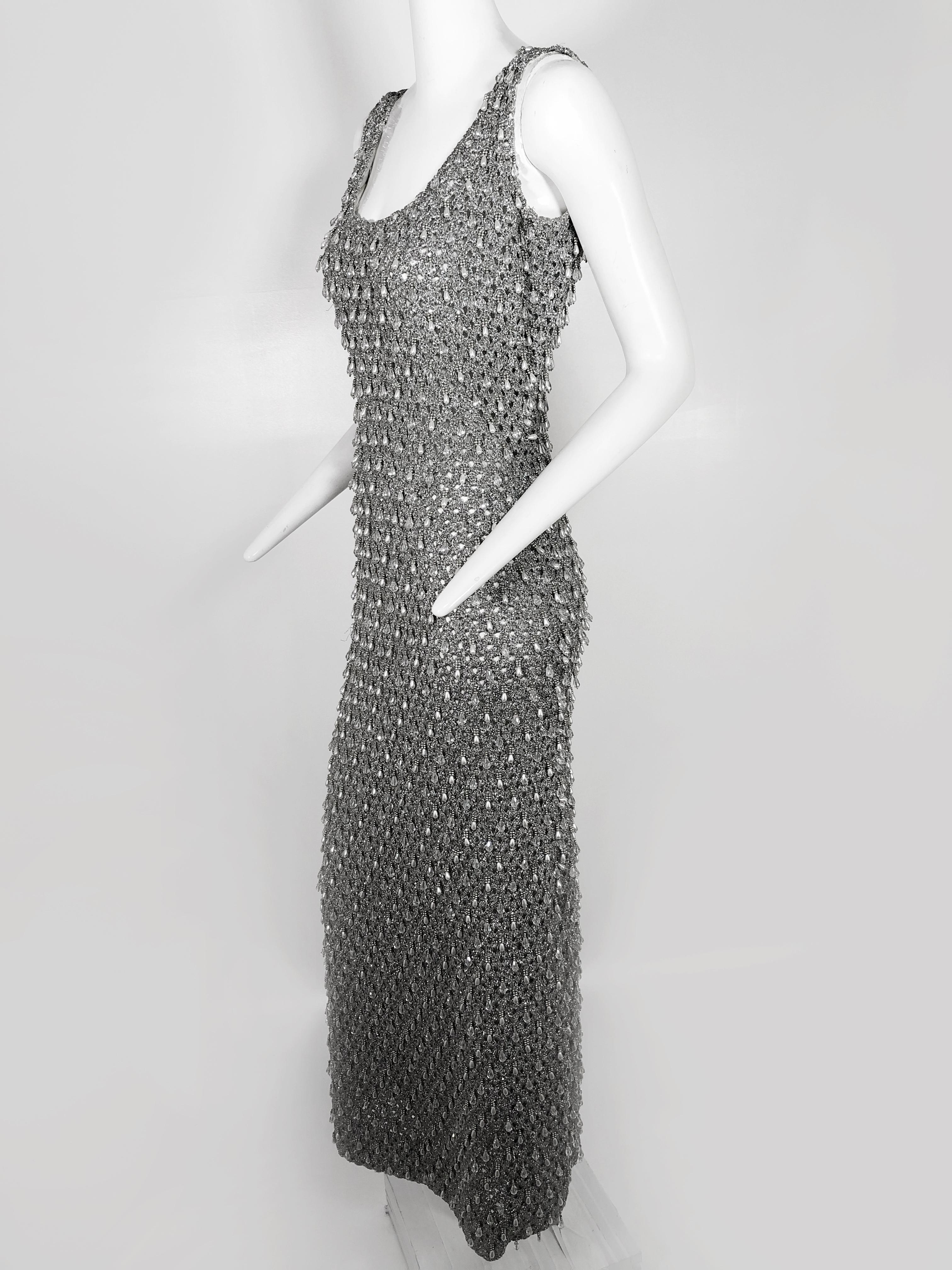 A fabulous 1960s silver lamé crochet gown covered with faux pearl and crystal beaded teardrop fringe.  Completely silk lined with 19