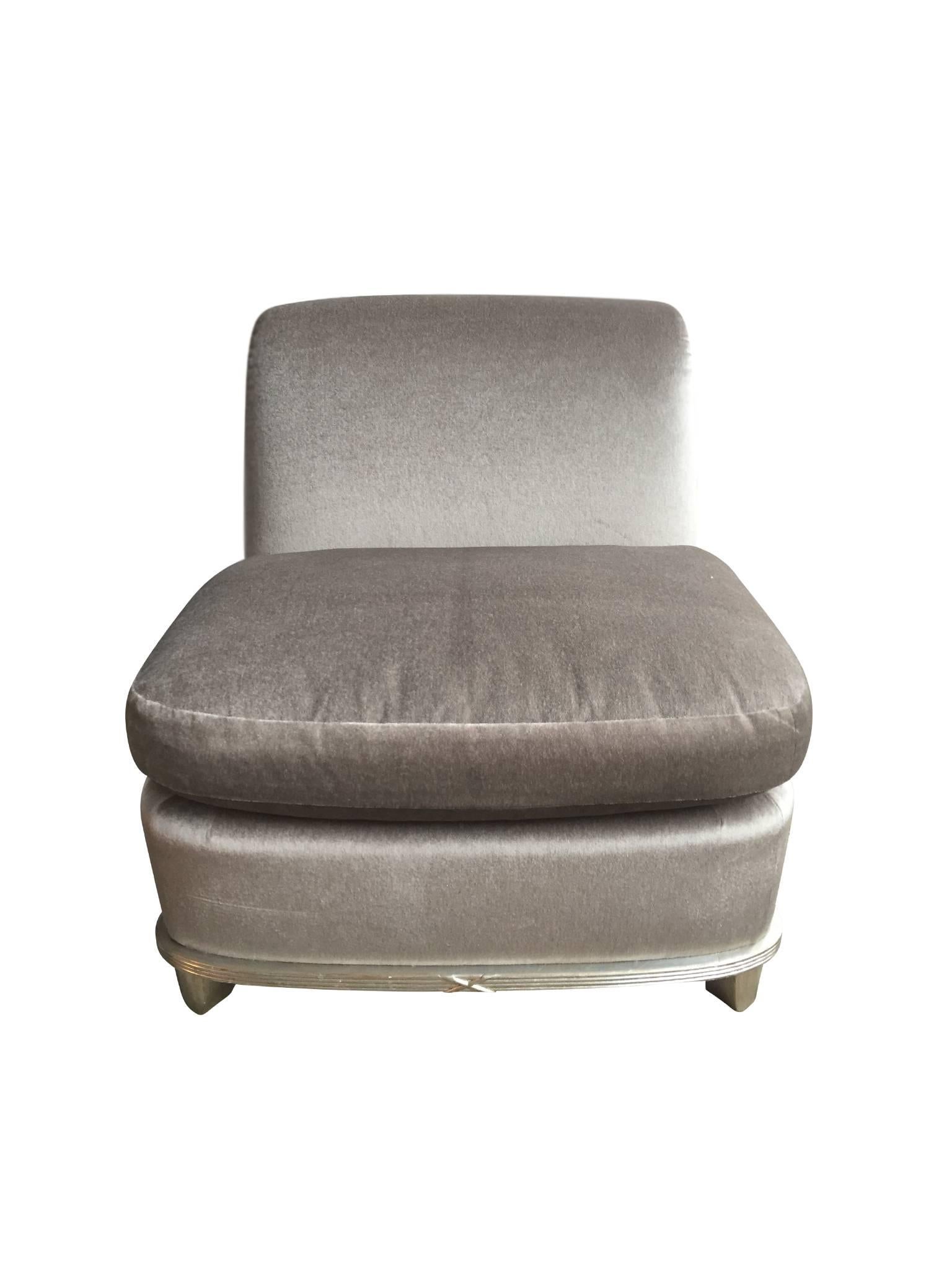 This stunning lounge or slipper chair was made in the 1960s. It was recently reupholstered in a silver mohair, which catches the light and shines beautifully. Along with this soft upholstery, the cushioning is plump and comfortable. This is a chair