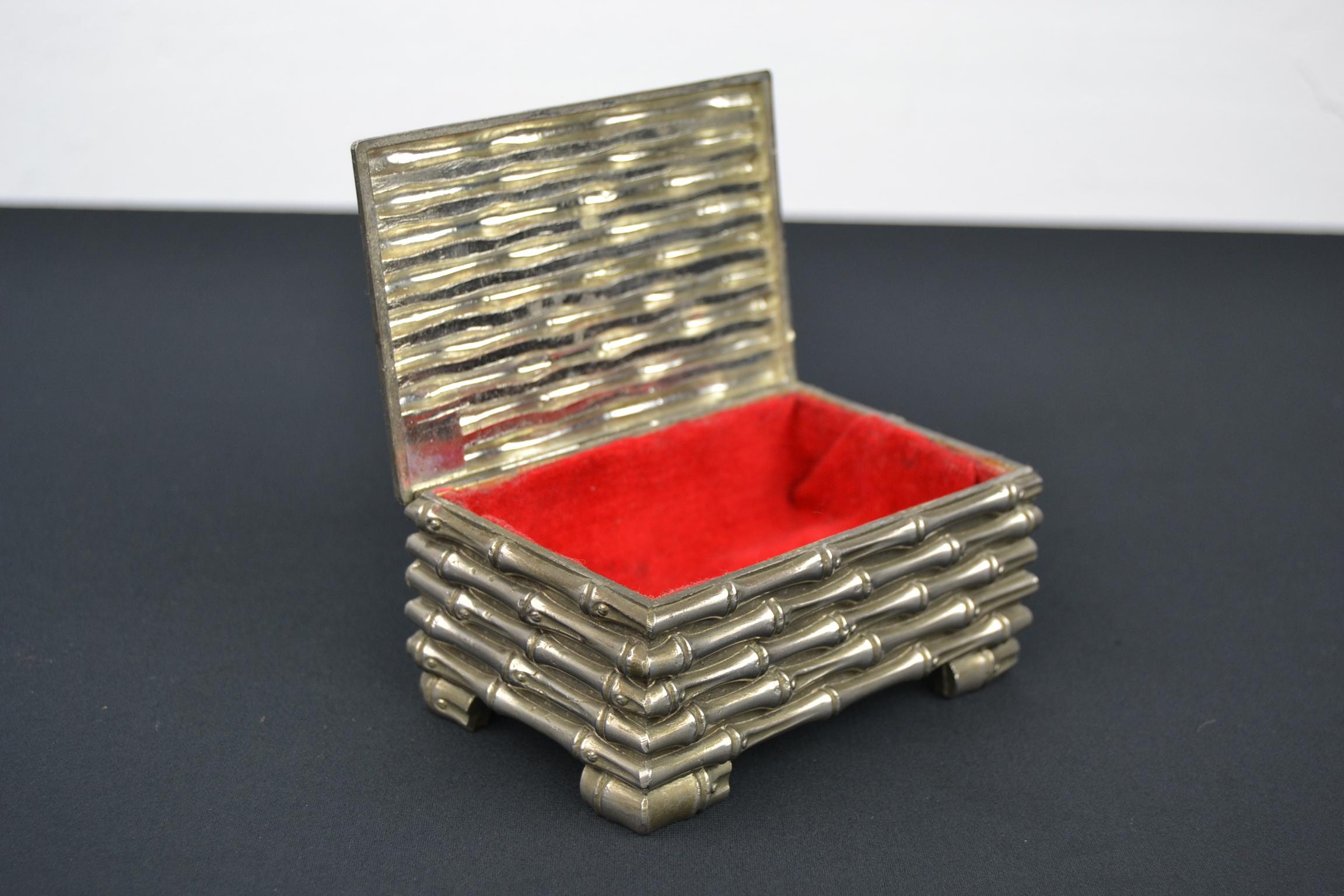 Silver plated faux bamboo box by Maison Baguès.
A stylish French little jewelry box, trinket box or storage box
in metal faux bamboo with red velvet inside. Embossed bamboo sticks on top of the lid and all around.
A silver plated footed casket