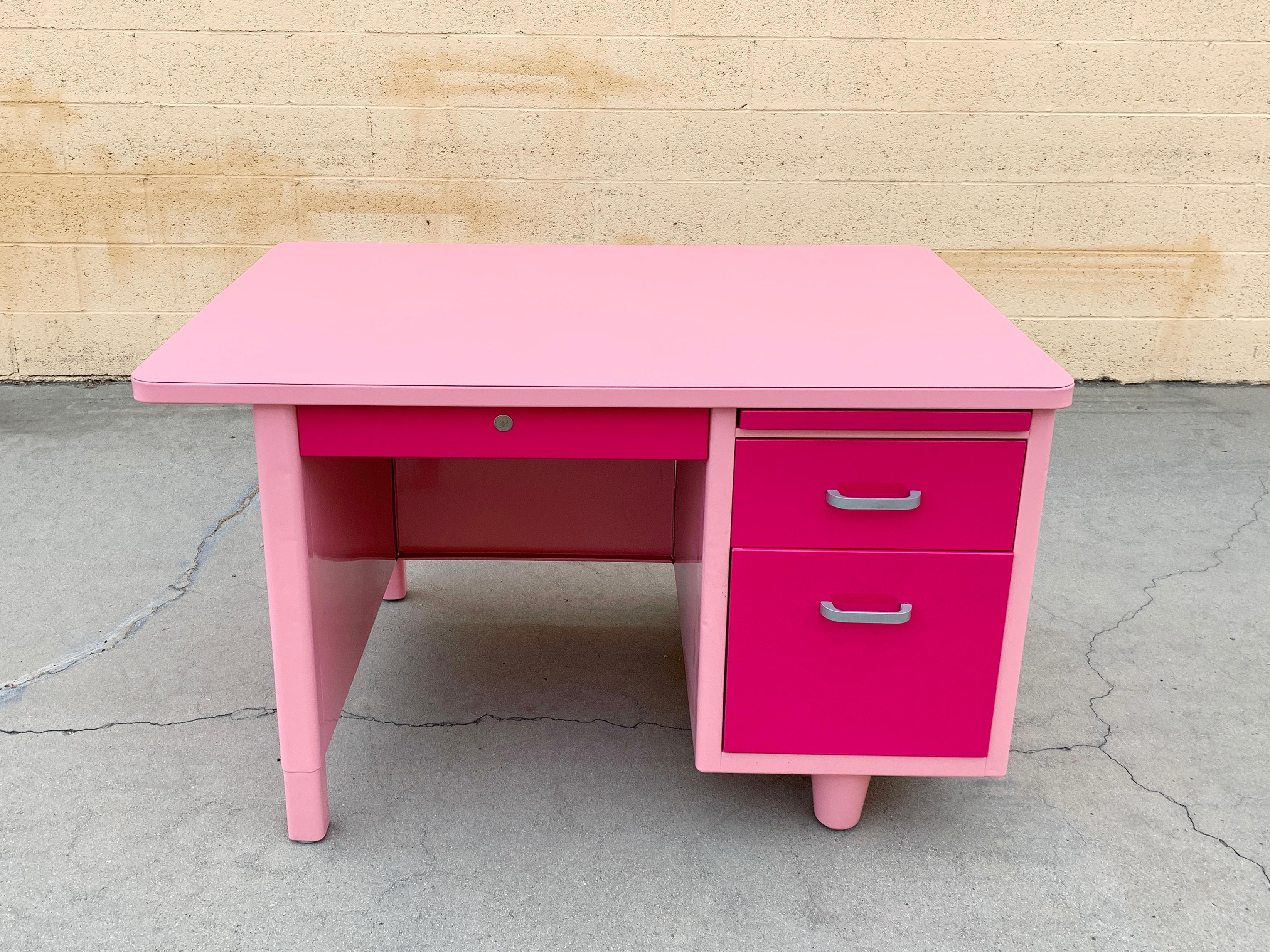 In stock and ready to ship! 

Who says tankers can't be cute?! This Classic 1960s single pedestal desk is pretty in pink and ready to add a little love to your space. Newly refinished in two-tone of RAL 4003 and RAL 3015 with brushed aluminum