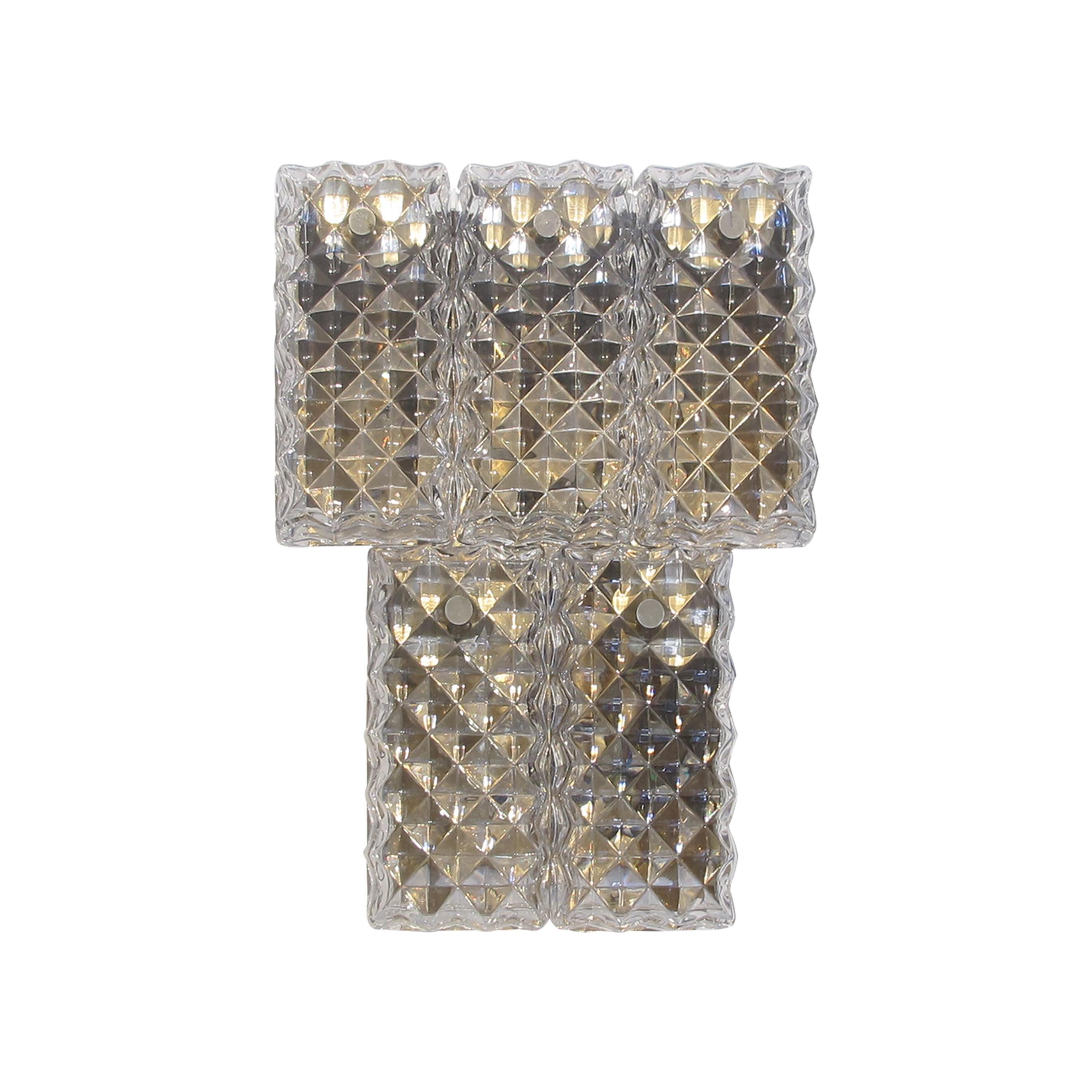 Single two-tier Kinkeldey wall light from the retro period, 1960s. Crafted with meticulous attention to detail, the light features textured glass plates with prism shapes to refract the light. The wall light holds four panes of glass held onto the