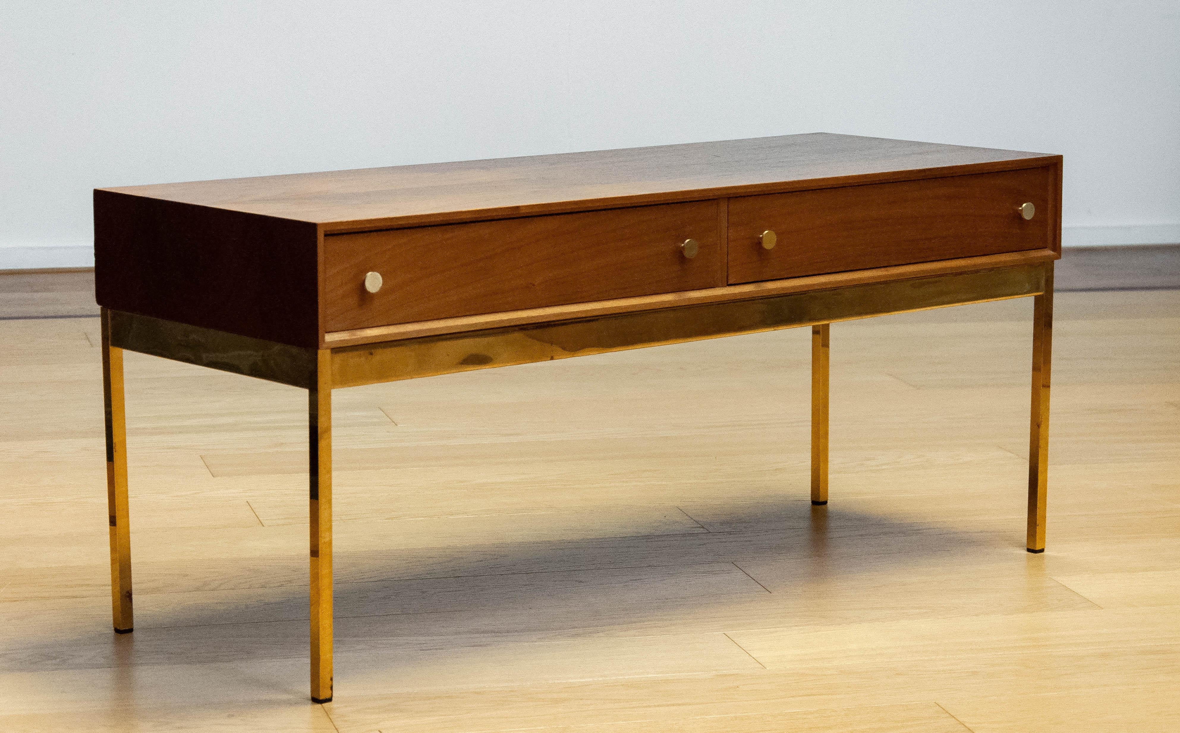 Beautiful and elegant slim drawer sideboard in walnut with brass details resting on slim brass legs. This sideboard, model 60, is designed by Alf Svensson and Ynvar Sandström for the AB Nybrofabriken in Nybro Sweden.
This elegant cabinet is a
