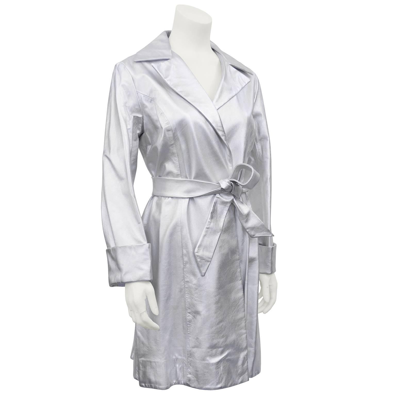 The perfect retro piece. Silver kid soft leather trench coat. Notched collar, cuffed sleeves, slight swing shape and a matching belt. Can be worn with or without belt. White polyester lining. No buttons. Excellent vintage condition,  very gently