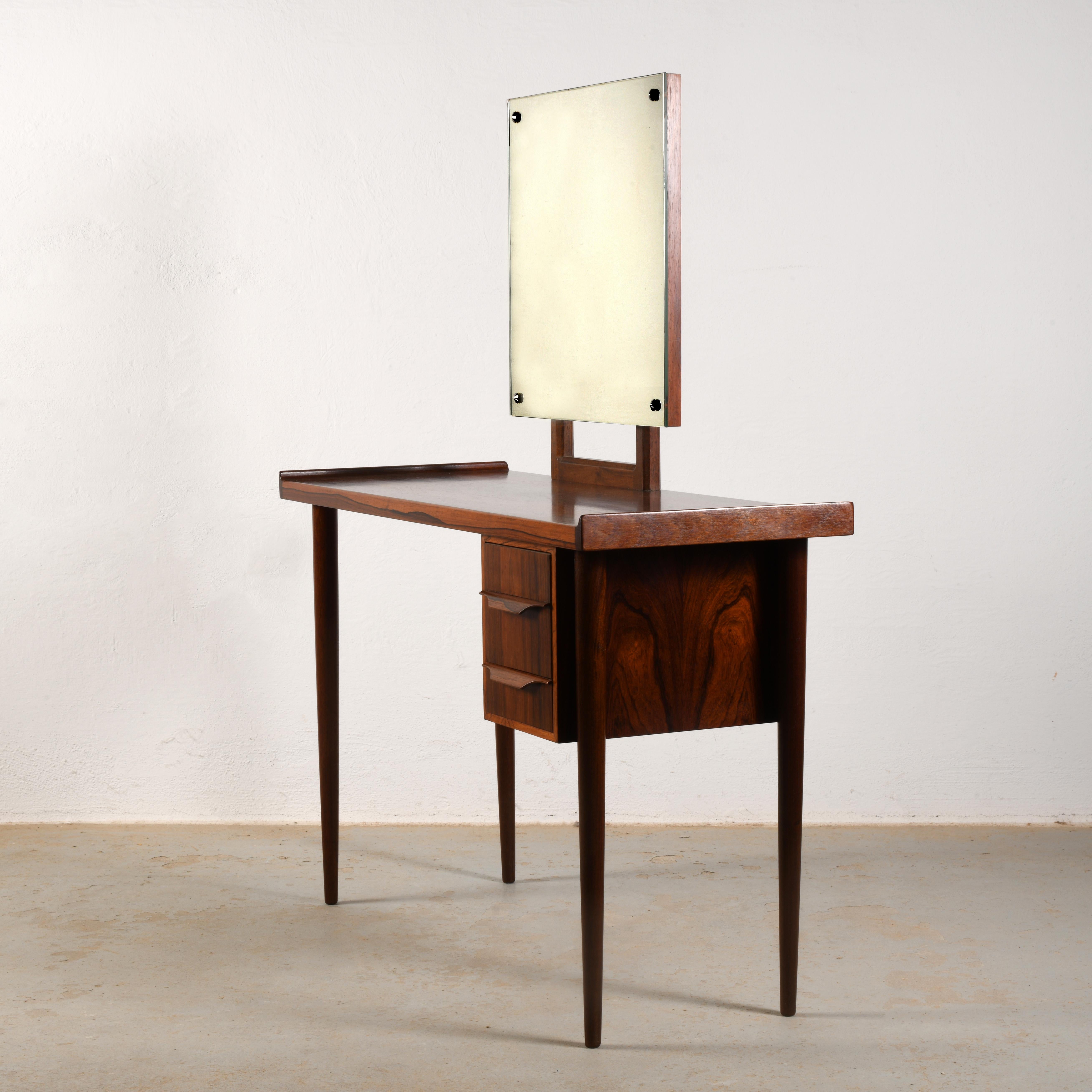 Pequeño tocador elegante de palisandro de los años 60 totalmente restaurado en excelente estado

La mesa, bien diseñada y fabricada, es flexible y puede convertirse en un pequeño escritorio retirando el espejo, que se quita fácilmente soltando dos