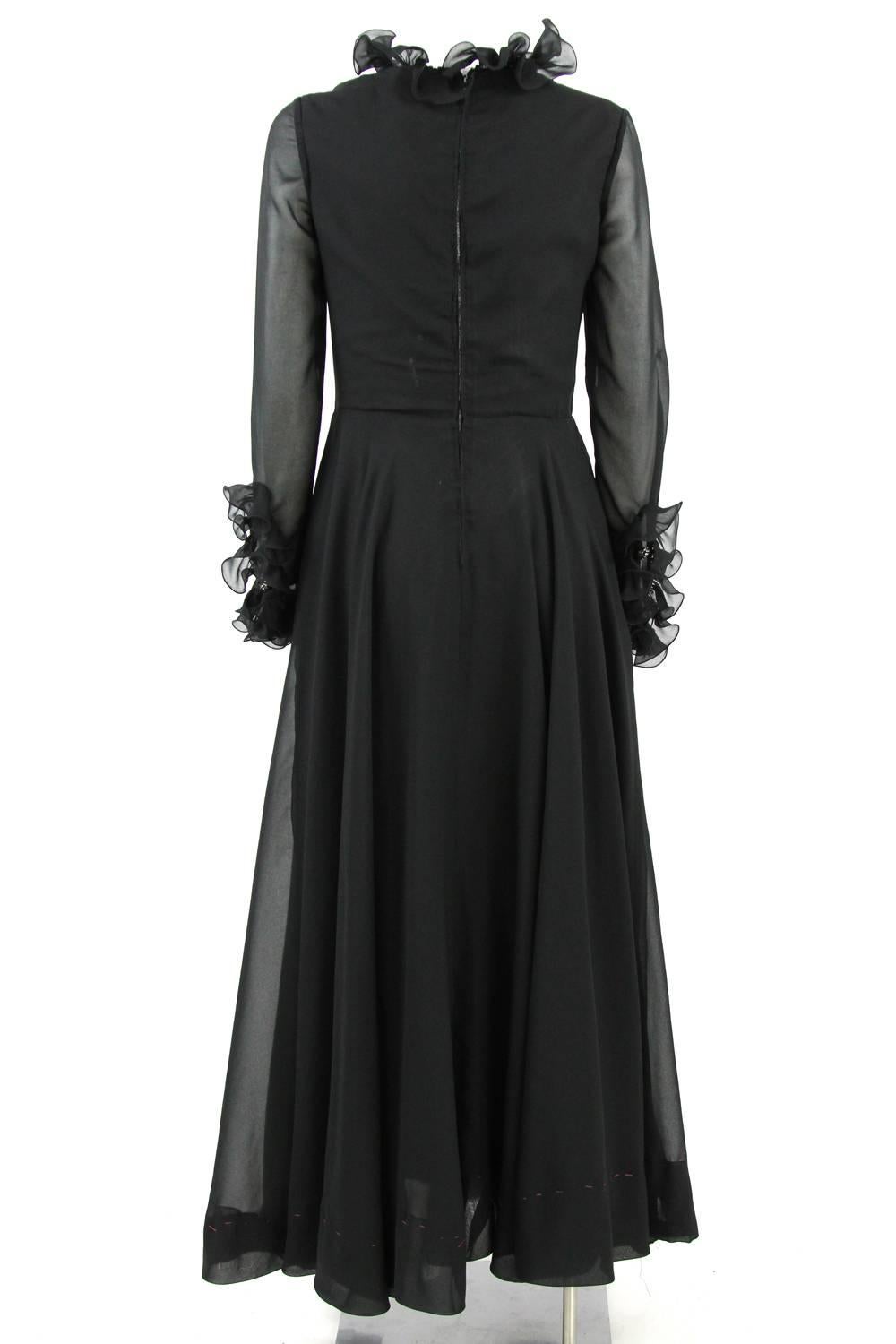 Polished long black 100% silk dress designed by high-fashion dressmakers Sorelle Fontana during the 1960s. With its elegant and feminine shape, this dress stands out for its light ruched details on the neckline and on the edge of its delicate,