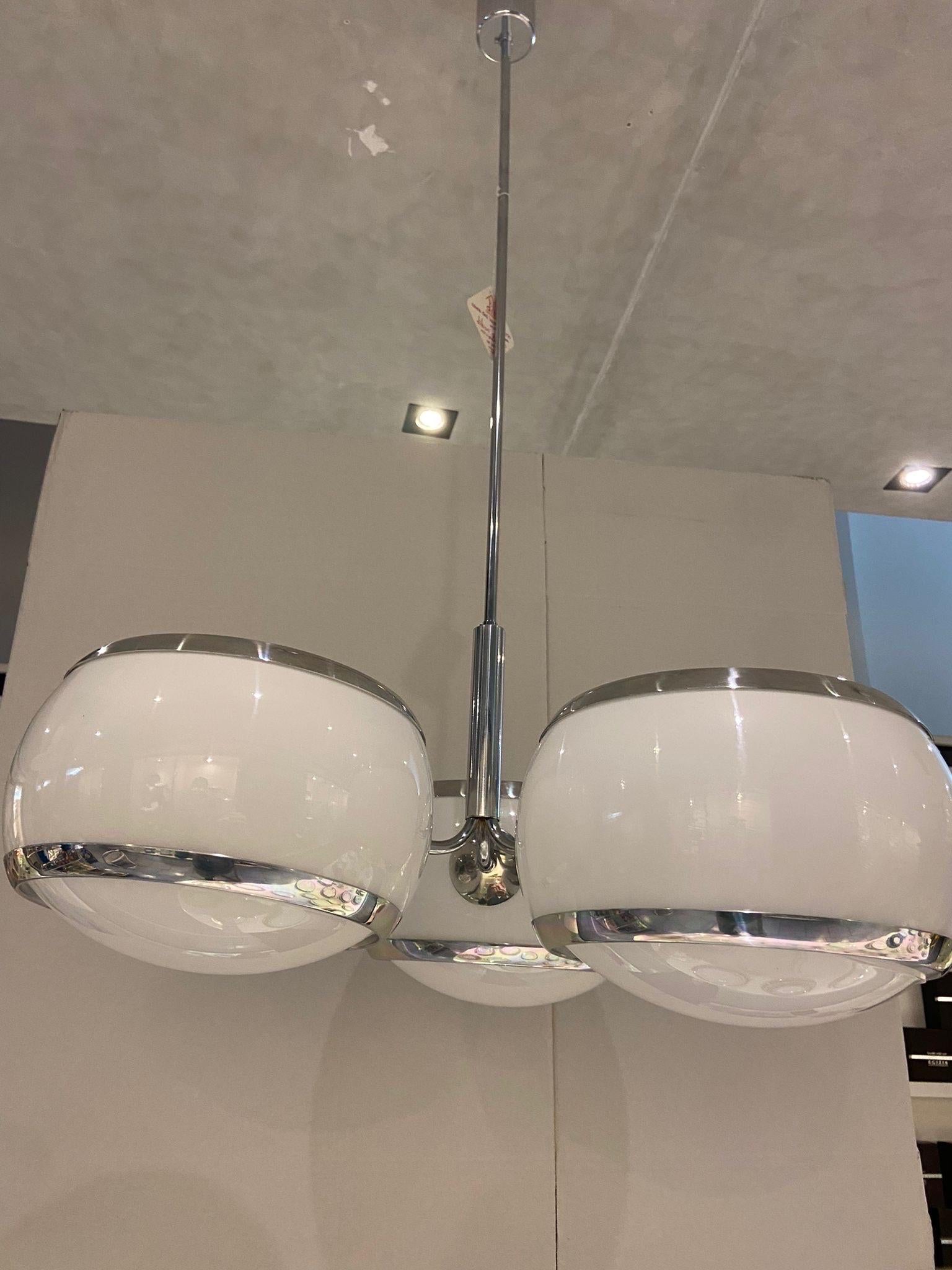 A white acrylic and chromed metal three-lights chandelier designed and manufactured in the sixties by Stilux. The chandelier comes from an important lighting shop that was going out of business, so it has never been installed in a home and,