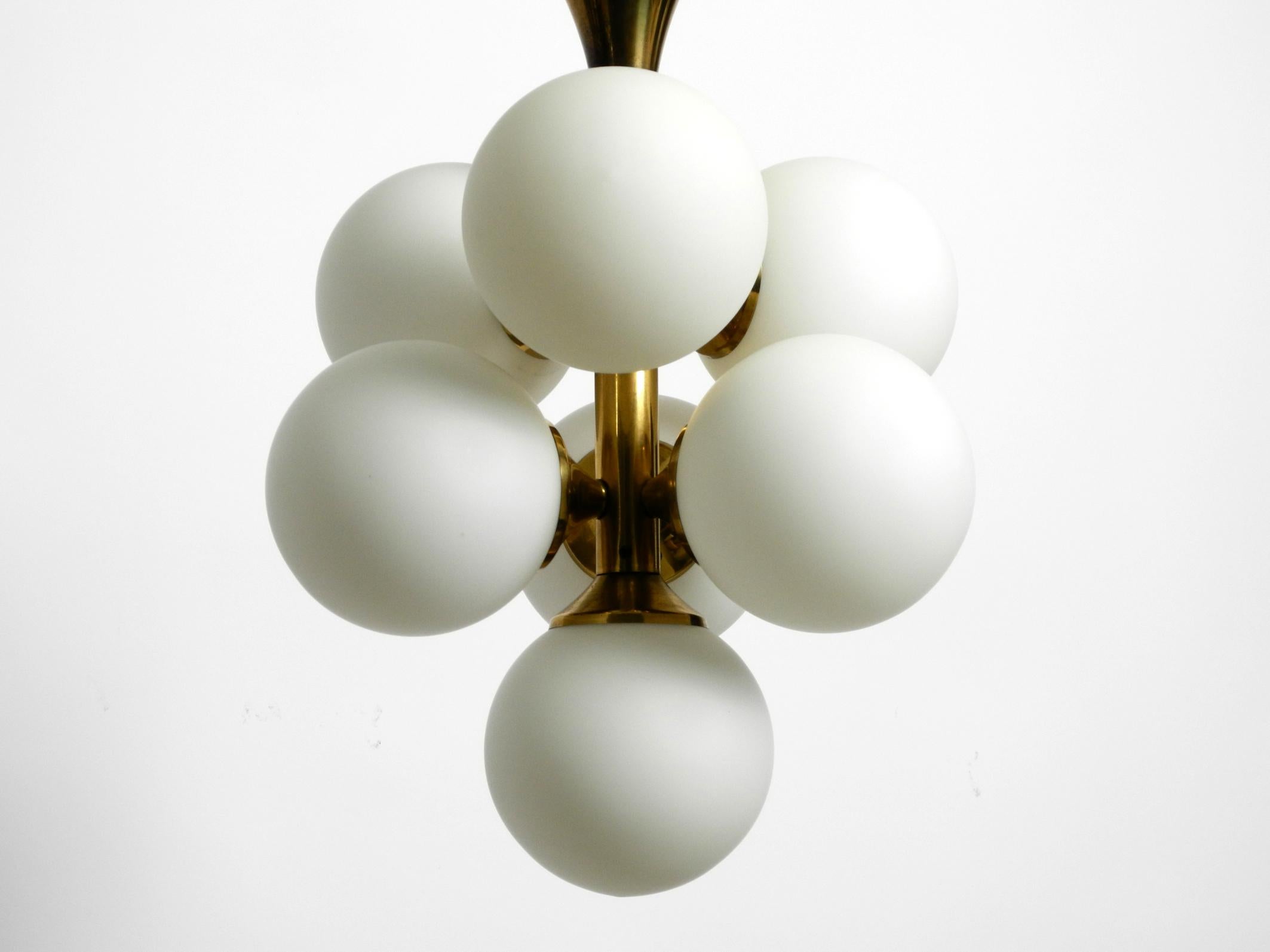 Beautiful rare 1960s brass ceiling lamp with 7 white glass globes.
Frame is completely made of brass.
Manufactured by Kaiser Leuchten. Made in Germany.
Gorgeous sixties Space Age design for great and glare-free light.
Seven E14 sockets for max.