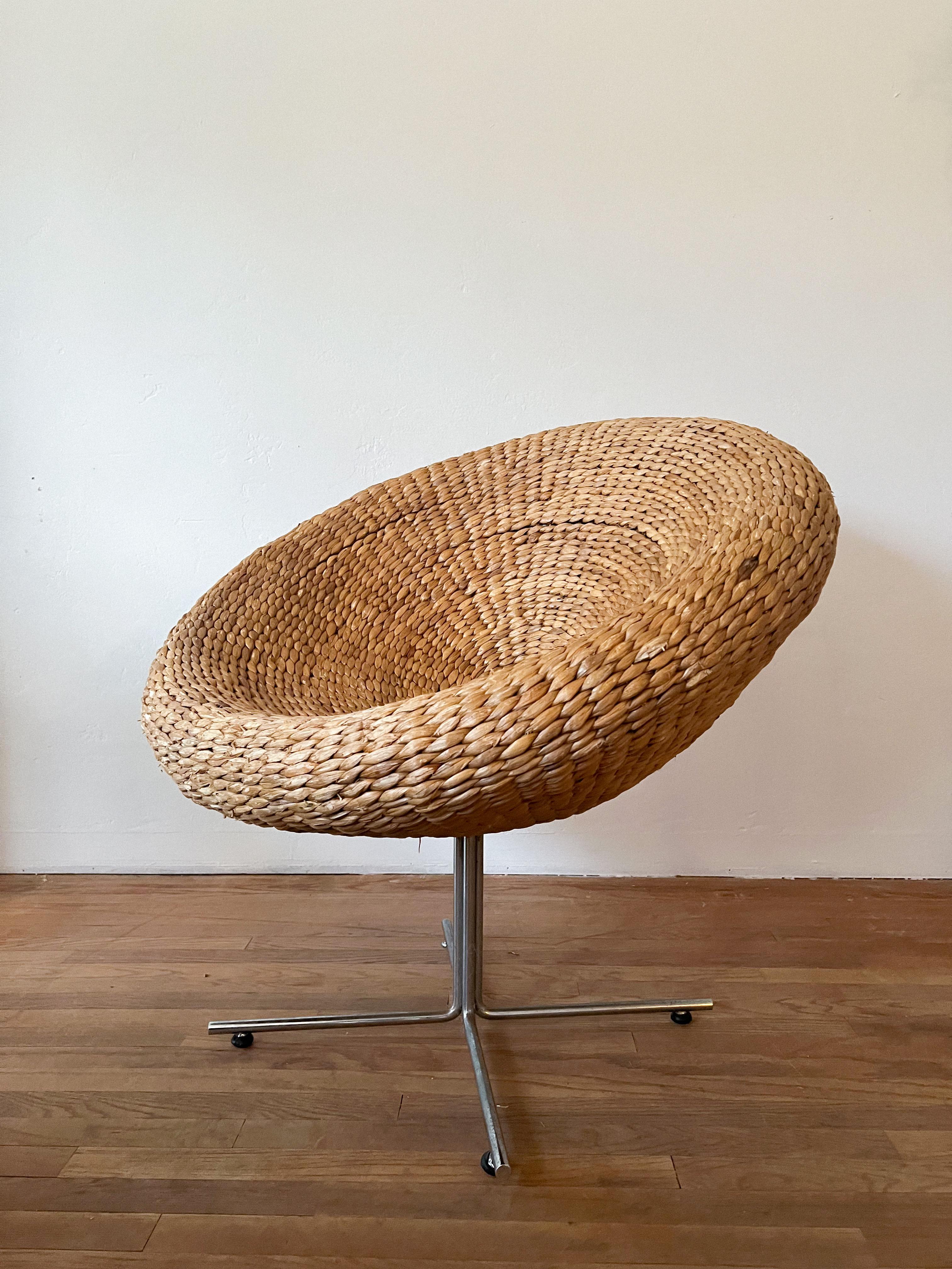 Space age pod/egg shaped lounge chair made of handwoven wicker with a very minimalistic chrome base. This is a great statement piece.