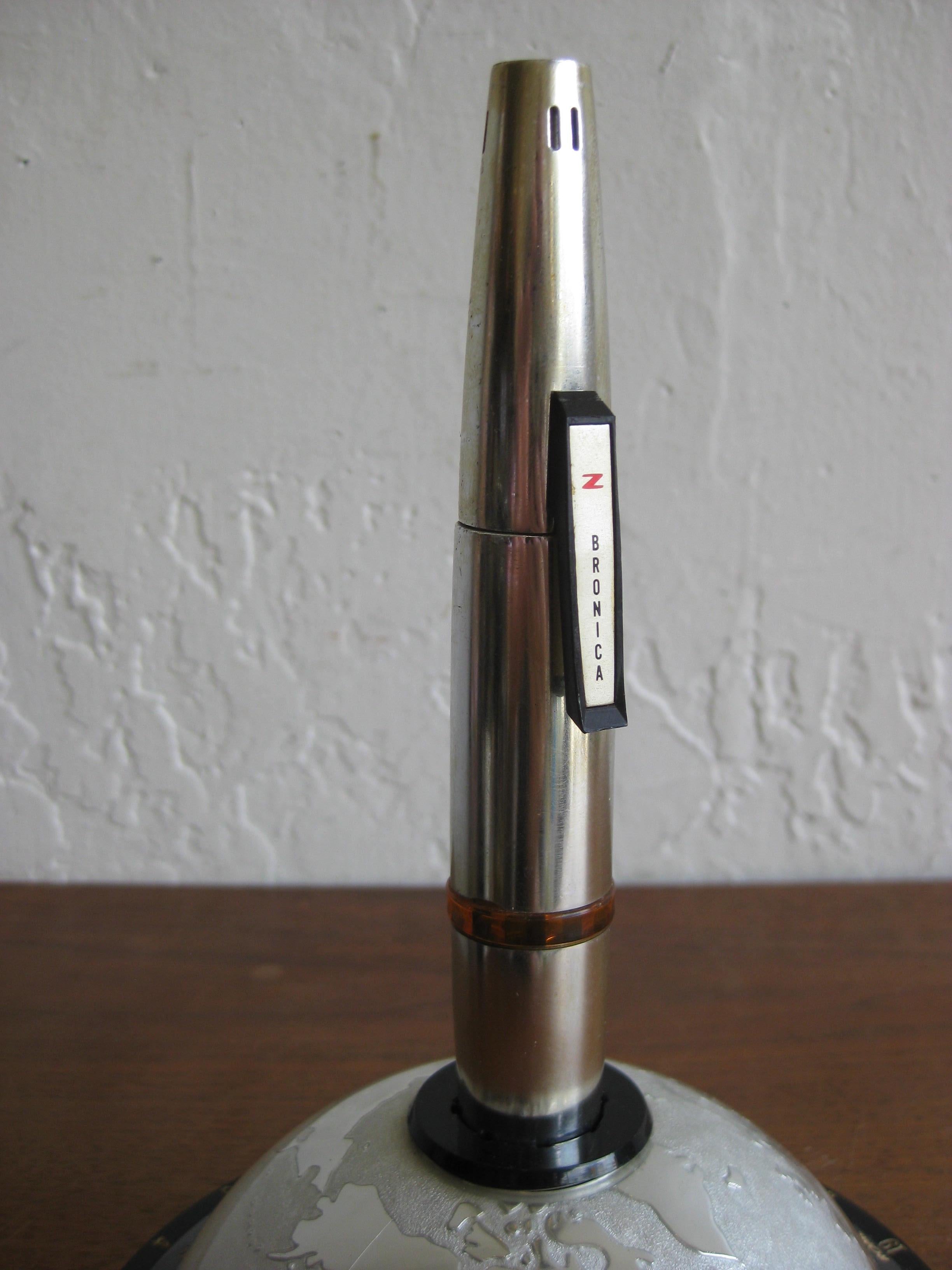 Great space age figural table lighter made by Zenza Bronica. In the shape of a rocket and the base is the globe. 1960s midcentury design at its finest. In very nice original condition, needing only butane to work.