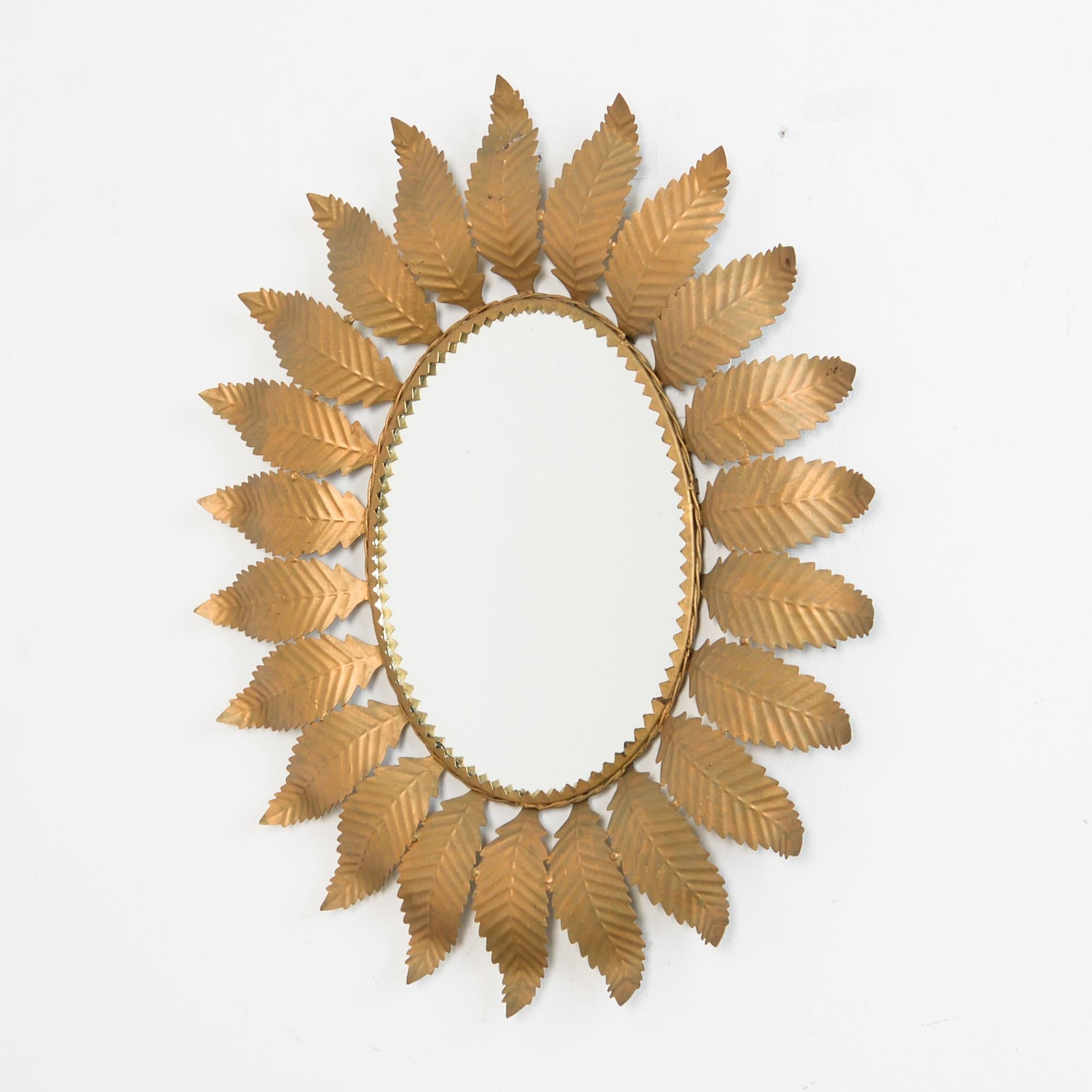 From Spain, circa 1960, an oval mirror framed by beaten metal leaves. With a rose gold tinted finish. A typical ‘1960s Spanish style plays on repetition, Baroque ornament, folk technique, and midcentury geometry. Chic and bohemian accent.