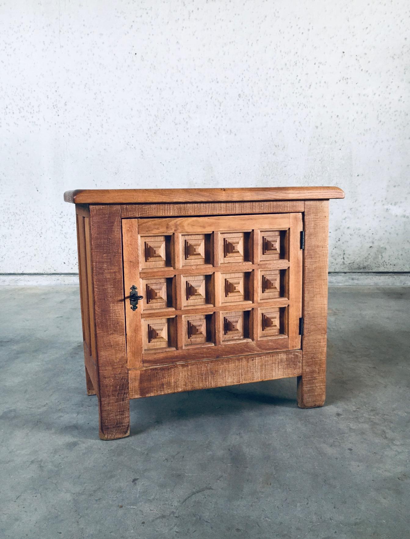Petite armoire vintage en chêne sculpté au design brutaliste espagnol. Fabriqué en Belgique, période des années 1960. De style espagnol, avec une façade géométrique typiquement sculptée. En chêne massif, avec clé en acier d'origine. Une porte
