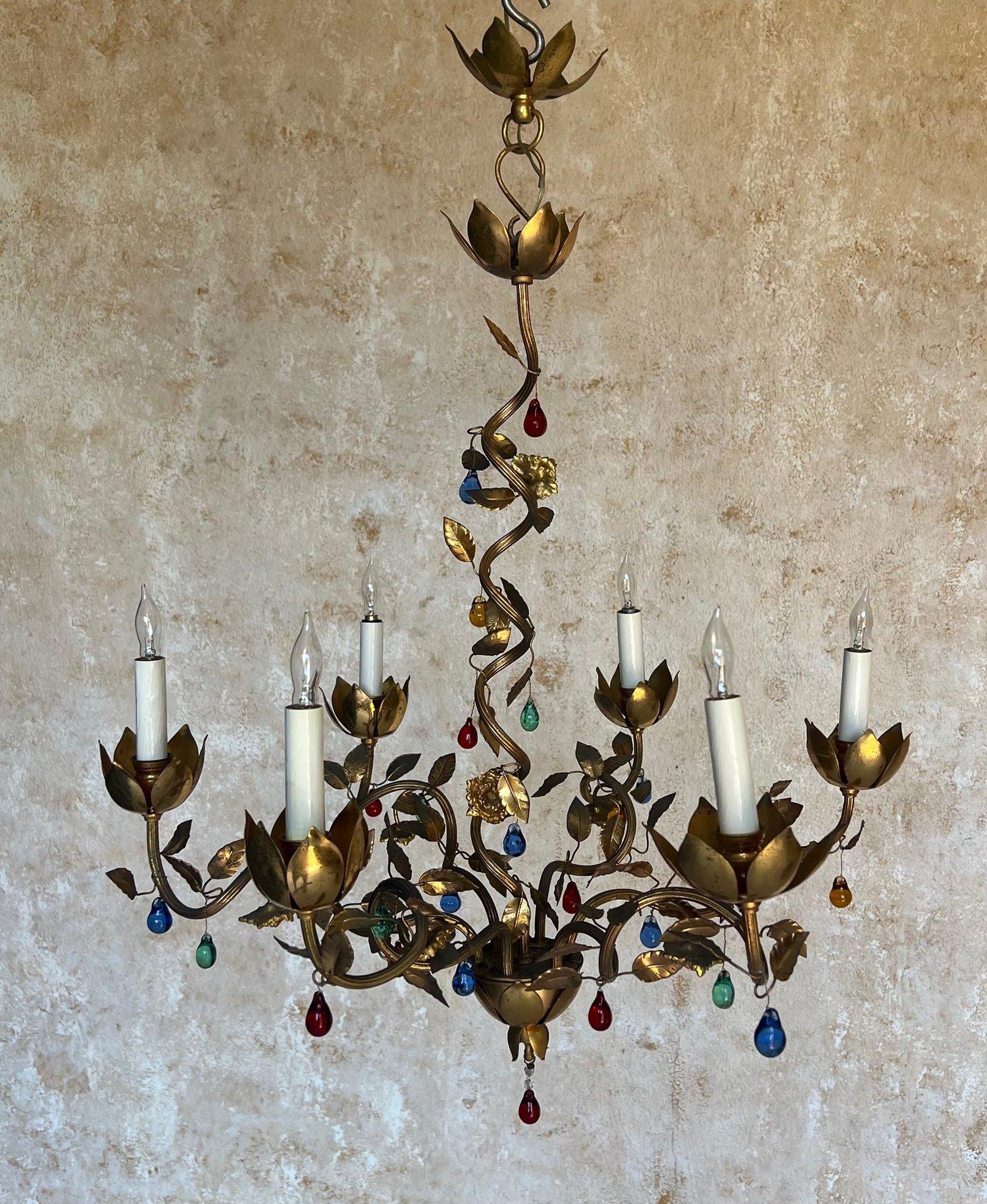 This remarkable Spanish 1960s gilt metal chandelier features six spiraling arms interwoven with intricately designed leaves replete with colored glass accents. This exceptional piece is in very good vintage condition and has been recently rewired to