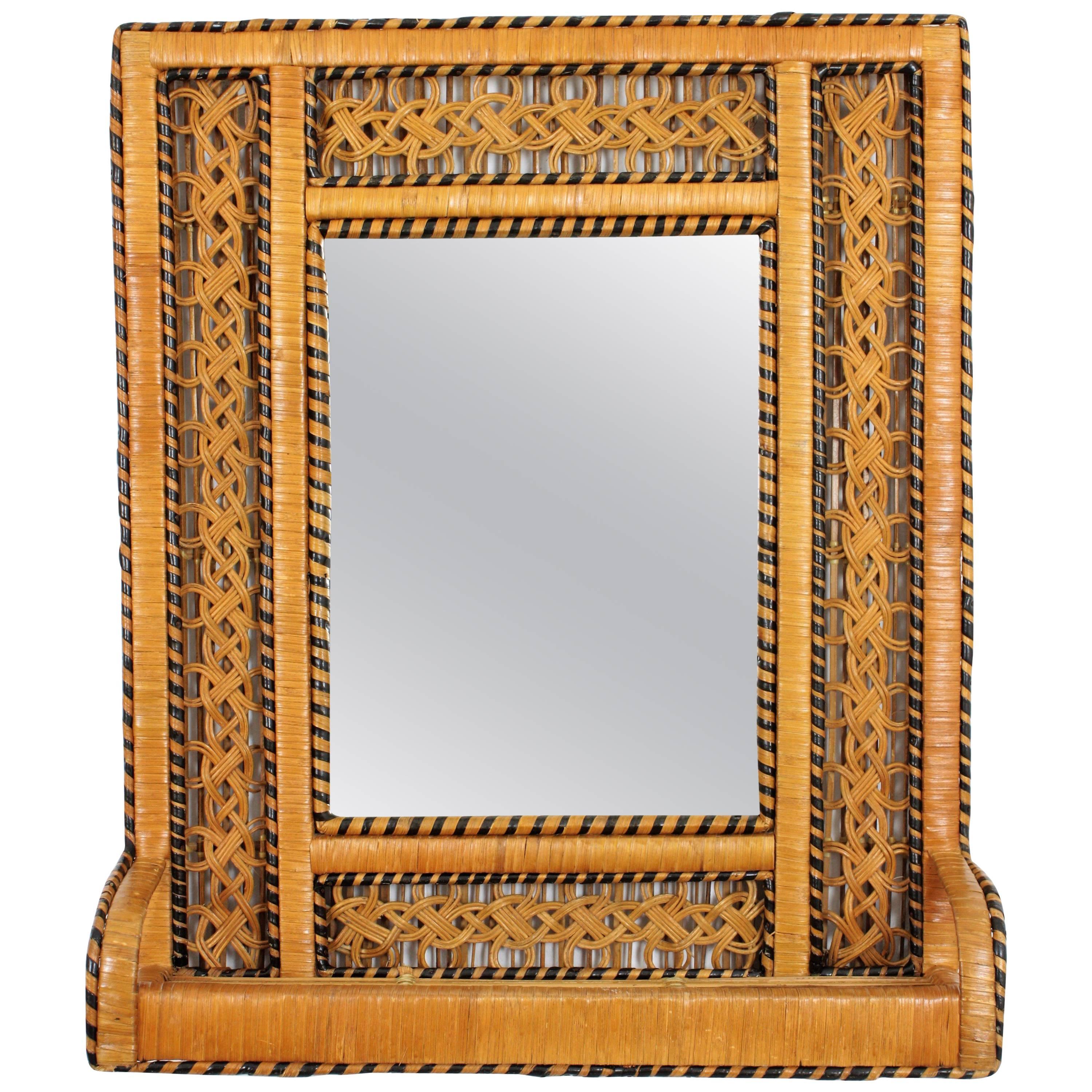 Lovely boho style handwoven rattan and wicker shelf mirror with black accents in the manner of the Emmanuelle peacock chair. Spain, circa 1960-1970s.
The frame has a meticulous handcrafted braided work that makes this piece full of beautiful